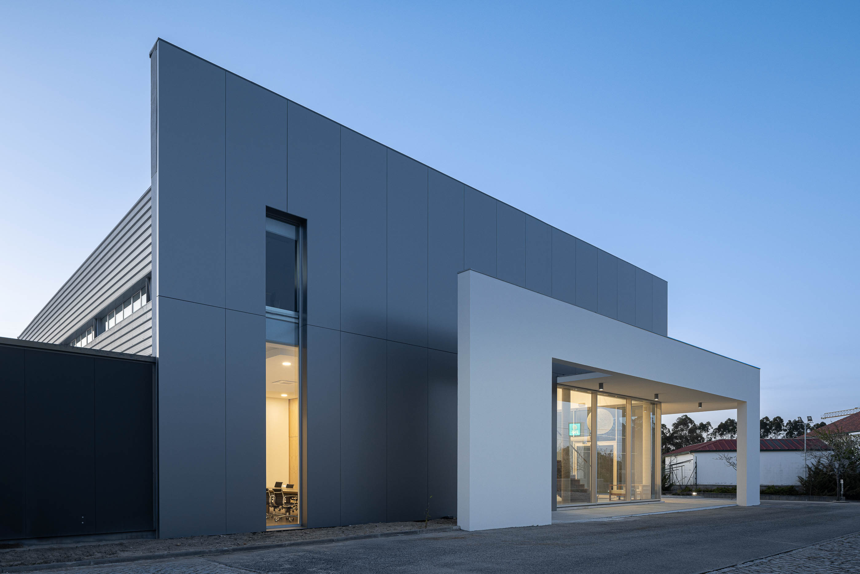 Entrada principal do edifício com escadas em madeira e candeeiro esférico. — Edifício Sede da PRF arquitetura Impare Arquitectura em Leiria