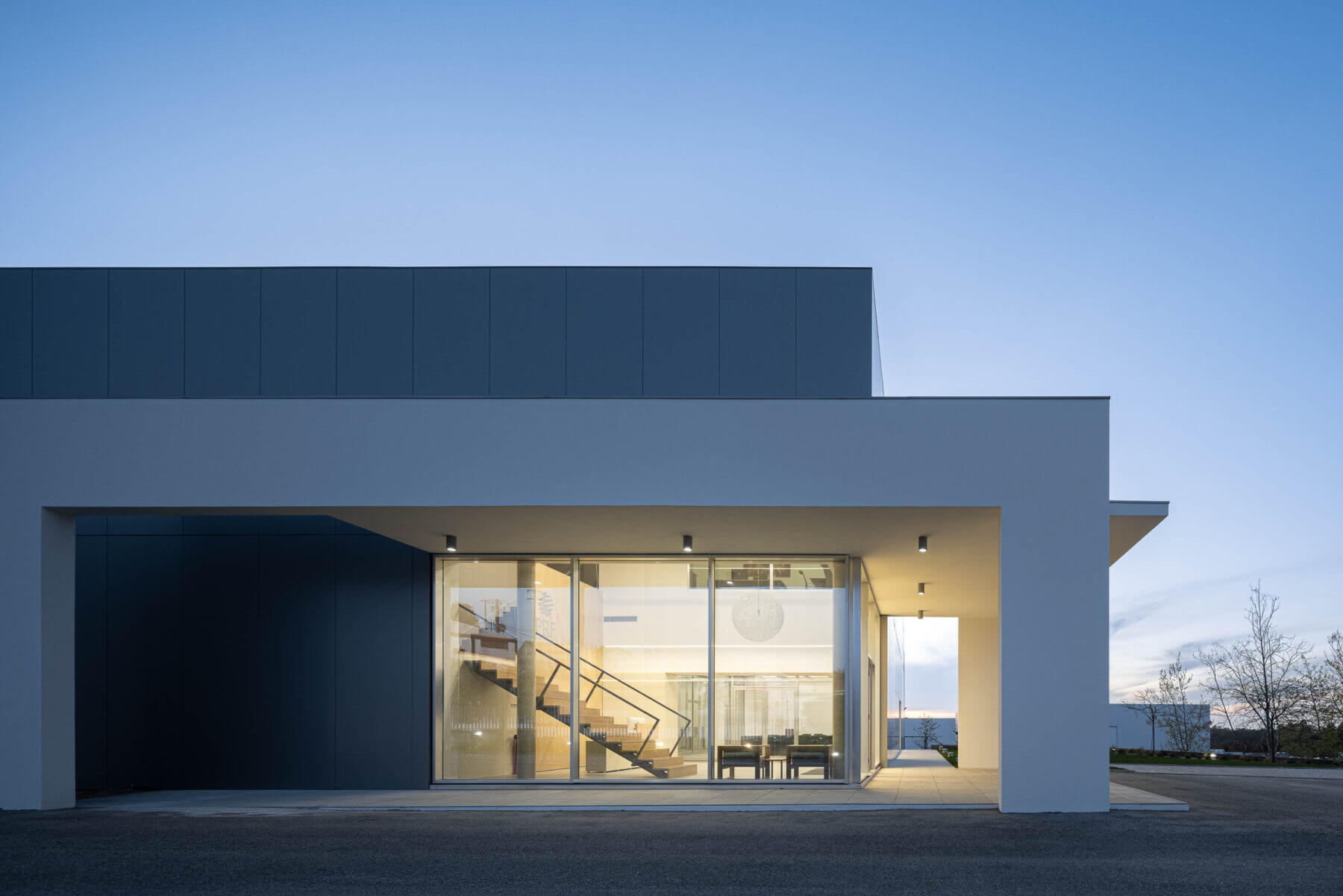 Fachada lateral do edifício com painéis cinzentos e janelas. — Edifício Sede da PRF arquitetura Impare Arquitectura em Leiria
