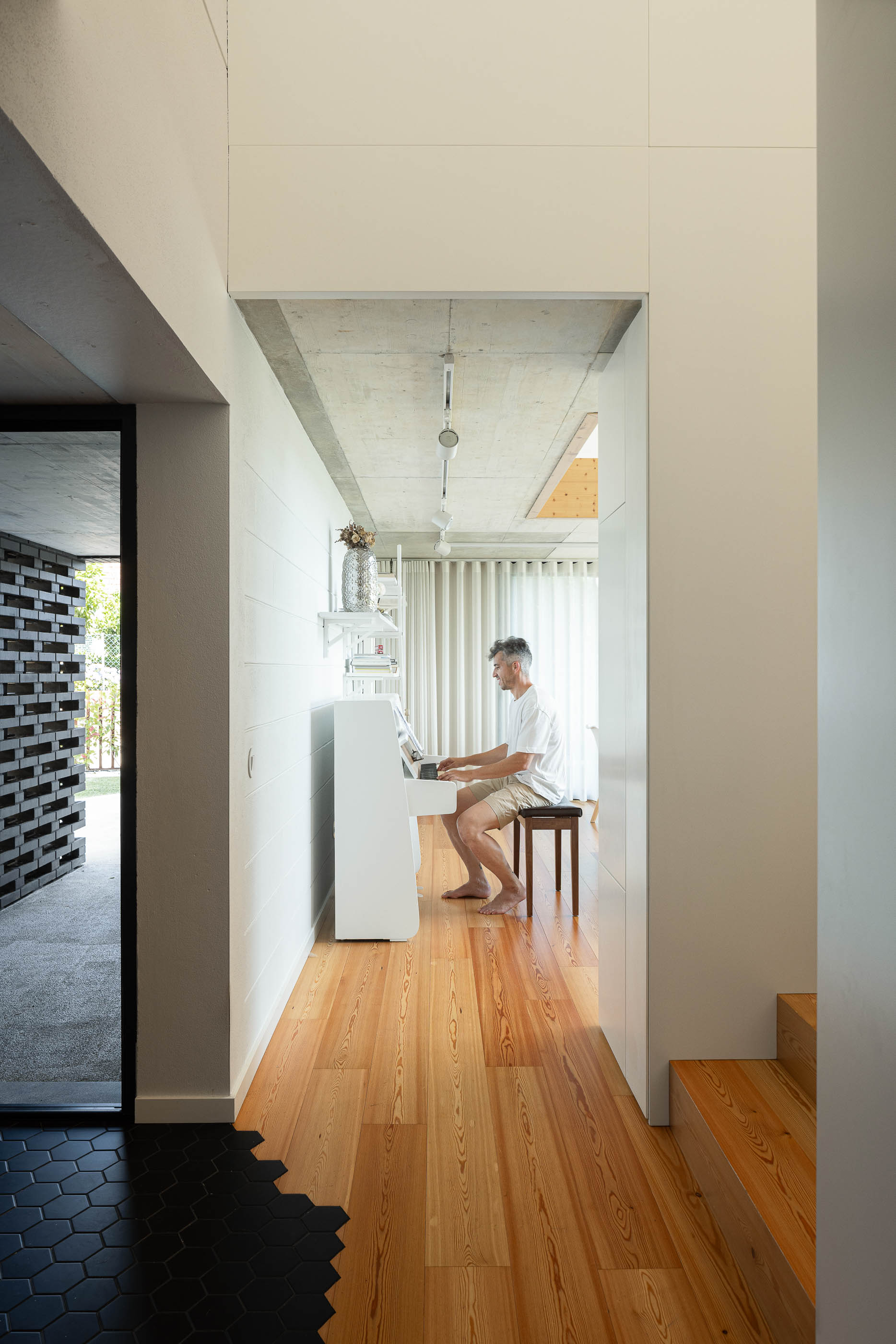 Sala de estar: Vista da sala de estar com estante embutida, televisão, alcatifa bege e mezzanine no piso superior. — Casa do Sobreiro arquitetura Skemba - Arquitectura e Engenharia em Amarante