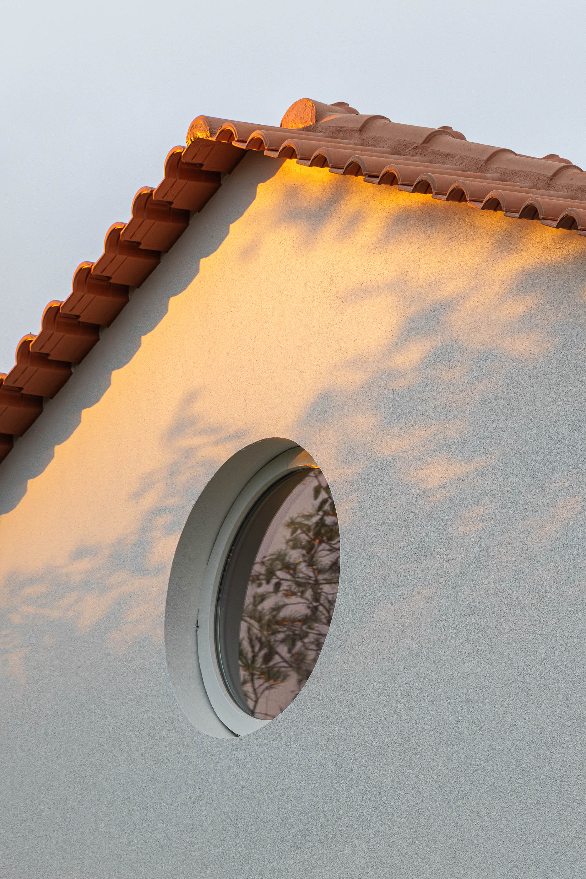 Exterior: Detalhe da fachada com janela redonda e telhado em telha cerâmica. — Casa de Sintra arquitetura Tsou Arquitectos em Sintra