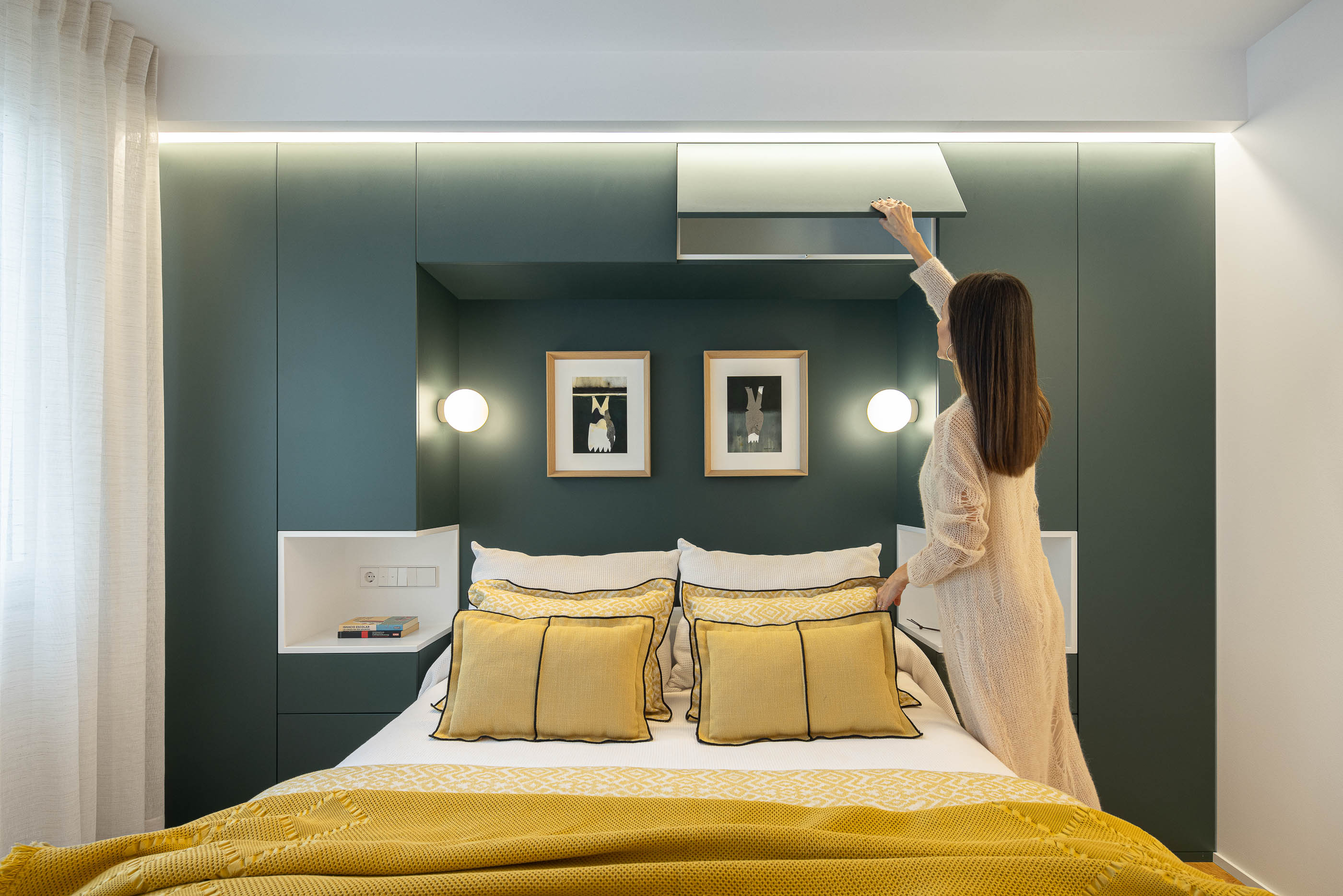 Quarto com cama de casal, cabeceira verde escura e candeeiros de parede. Roupa de cama amarela e branca. — Reforma Apartamento CV em Avilés arquitetura David Olmos Arquitectos em Avilés