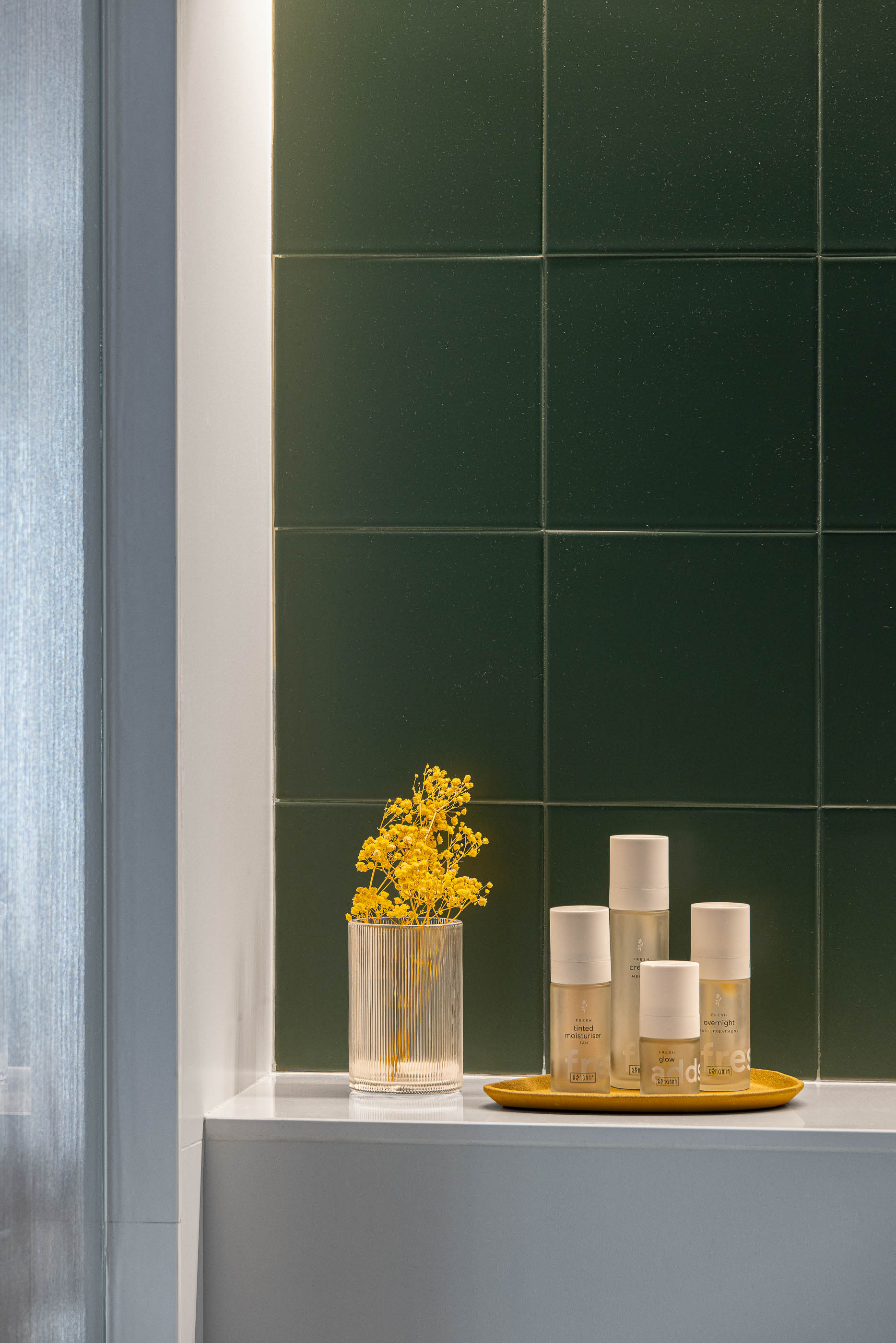 Casa de banho, detalhe do revestimento em azulejo verde escuro e produtos de higiene pessoal. — Reforma Apartamento CV em Avilés arquitetura David Olmos Arquitectos em Avilés