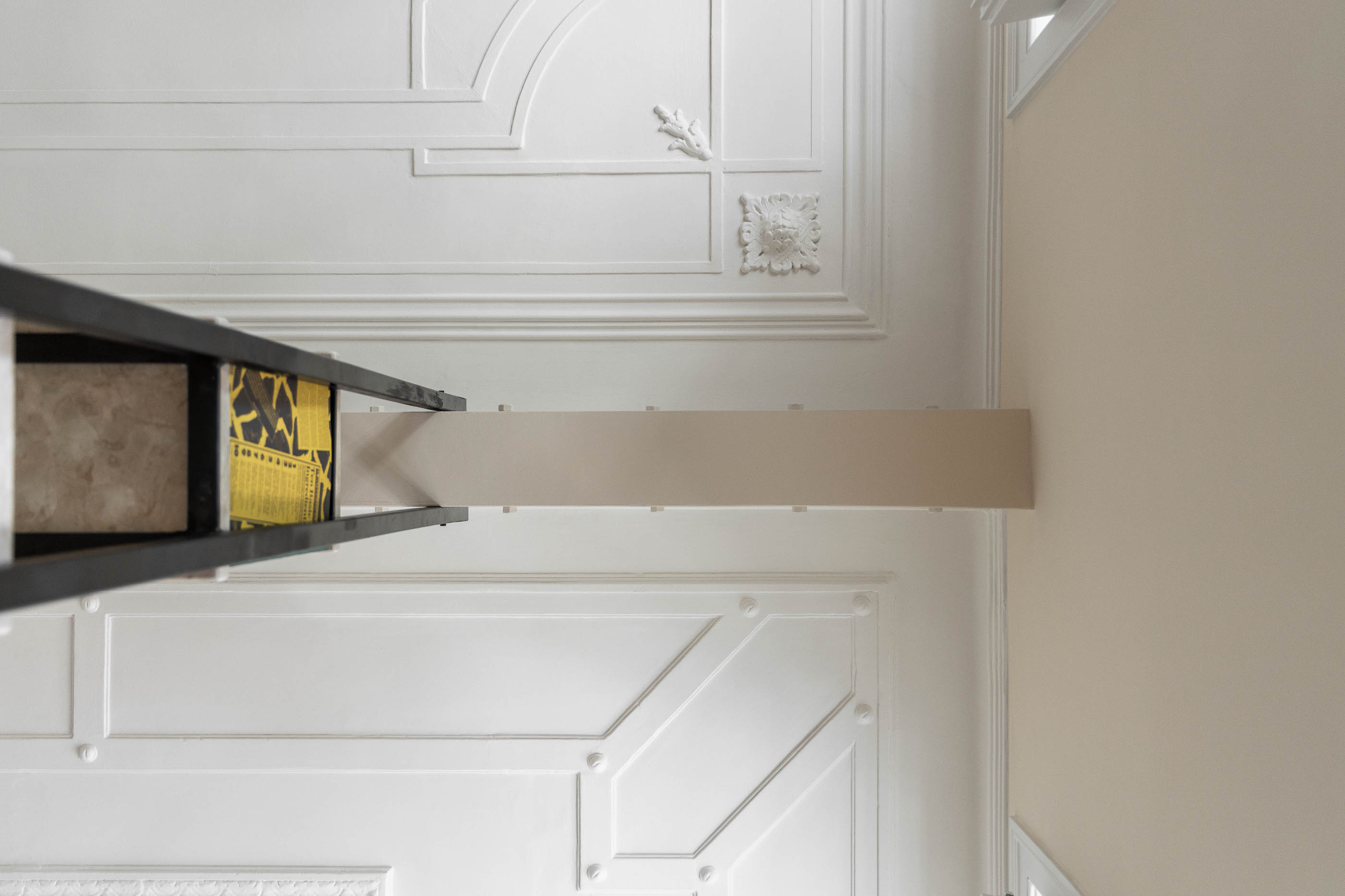 Tecto: Vista de baixo para cima do tecto trabalhado com estante metálica e prateleiras em pedra. — Apartamento da Penha arquitetura Paulo Moreira Architectures em Lisboa