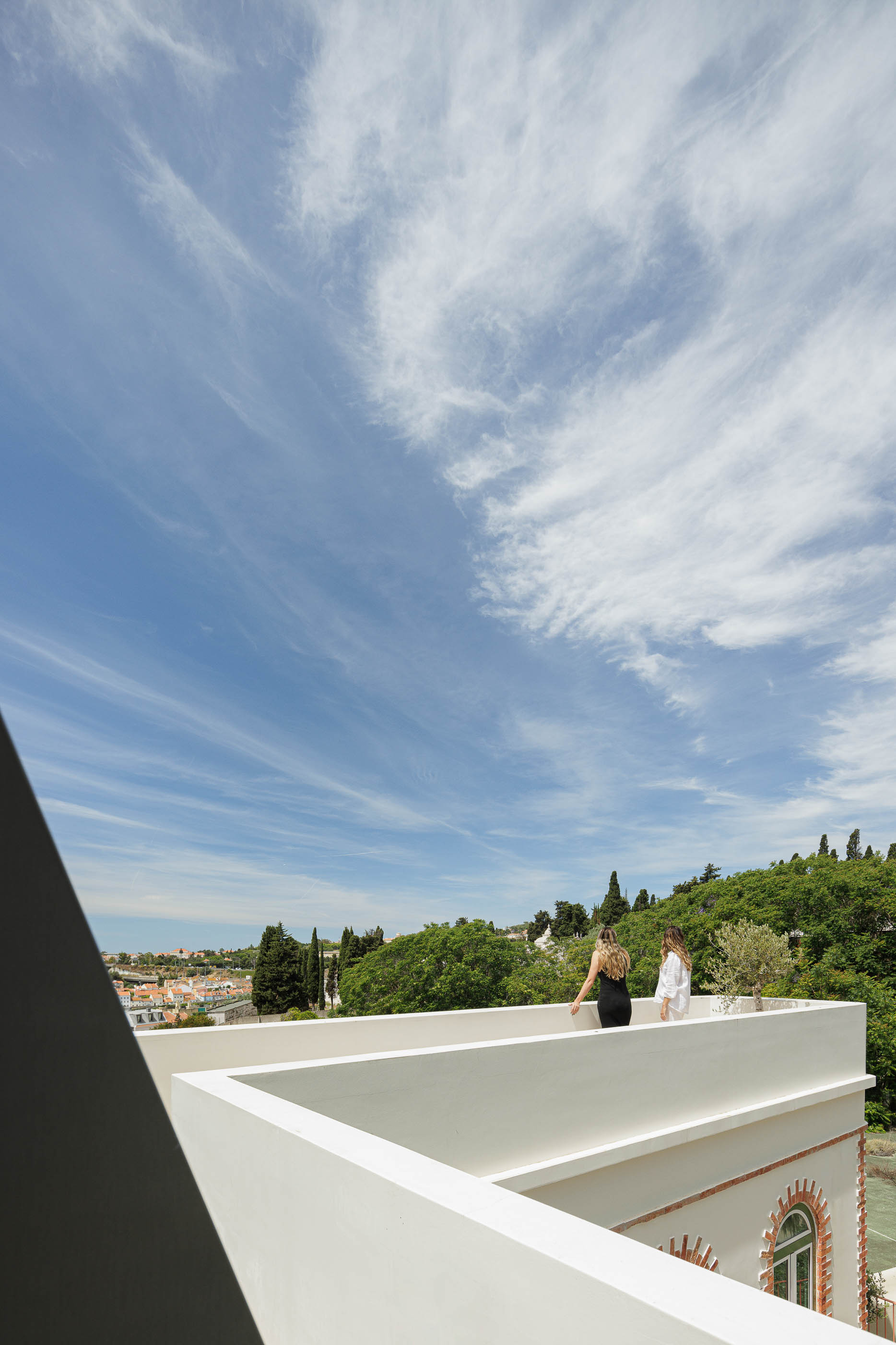 Terraço: Vista panorâmica da cidade e vegetação, com guarda-corpos brancos e céu azul. — Possidónio da Silva 37 arquitetura Fragmentos em Lisboa