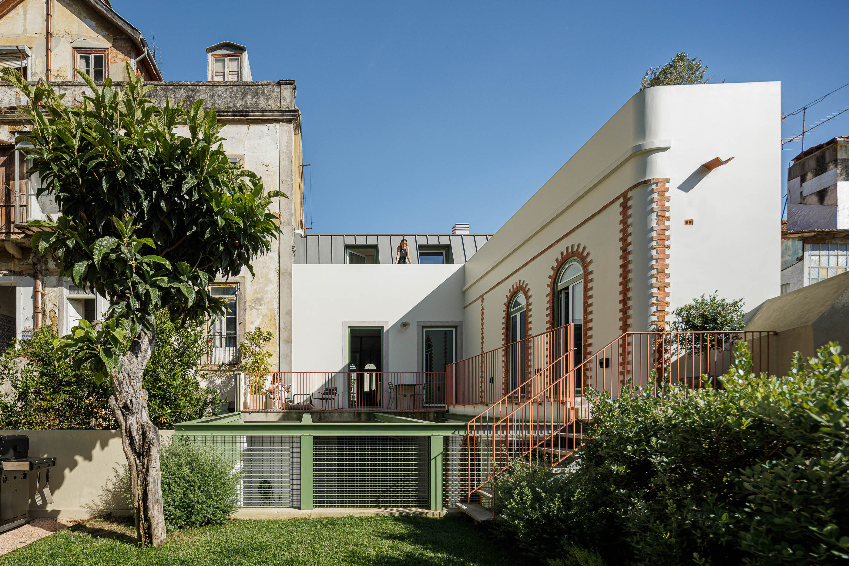 Exterior: Vista da casa a partir do jardim, com terraço, escadas cor de tijolo e detalhes em tijolo. — Possidónio da Silva 37 arquitetura Fragmentos em Lisboa