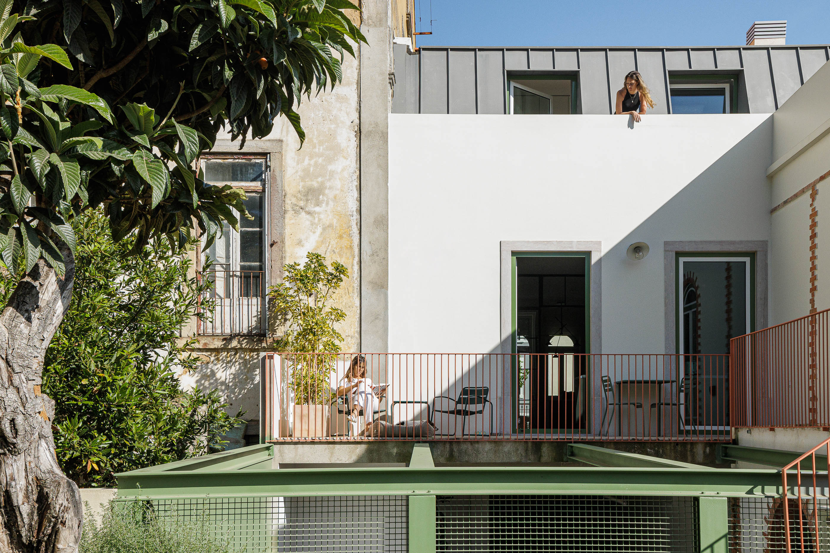 Exterior: Vista da casa com terraço, jardim e estrutura metálica verde, com detalhes arquitetónicos. — Possidónio da Silva 37 arquitetura Fragmentos em Lisboa