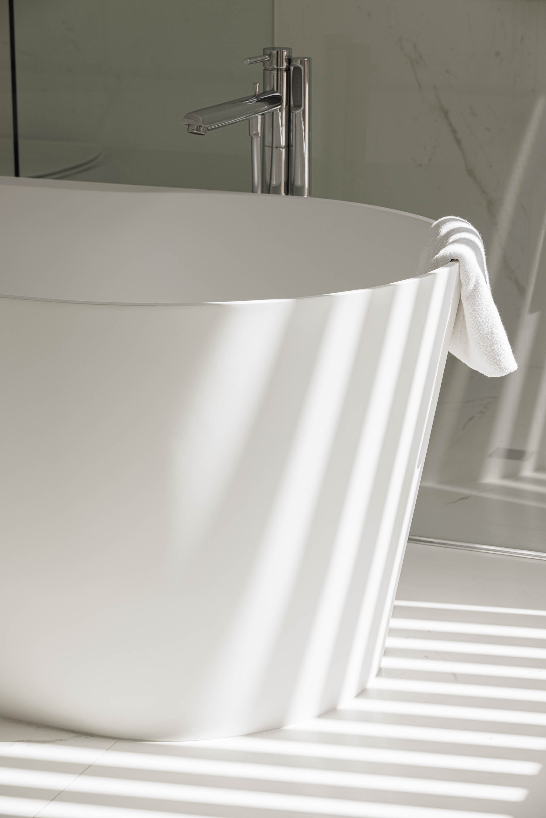 Casa de banho com banheira branca e torneira cromada. Revestimento em mármore branco. — Casa JC arquitetura Mário Alves Arquitecto em Coimbra