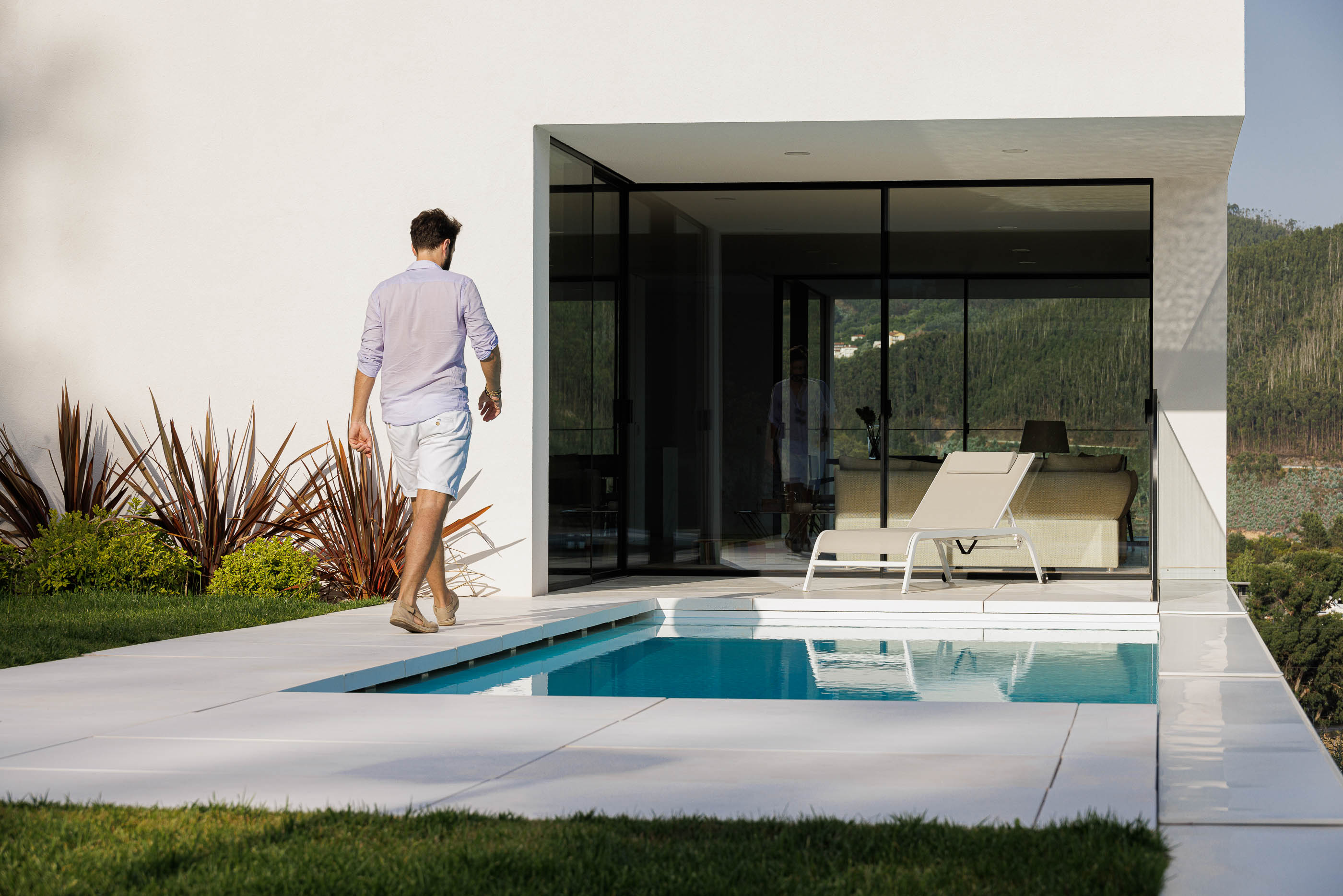 Exterior da casa com piscina e jardim. Arquitetura moderna com volumes brancos e grandes janelas. — Casa JC arquitetura Mário Alves Arquitecto em Coimbra