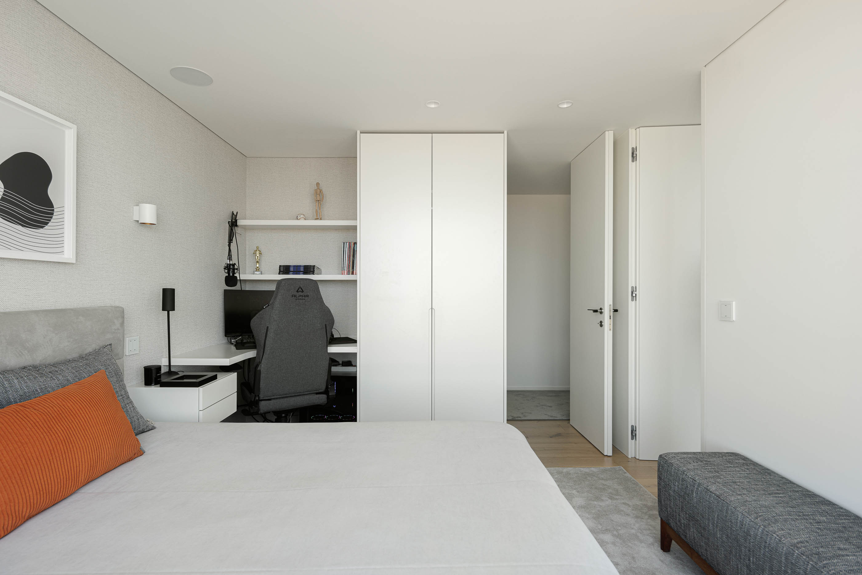 Quarto: Vista geral do quarto com cama, secretária, roupeiro branco e alcatifa cinzenta. — CASA [EN]COSTA arquitetura Hous3 em Guimarães