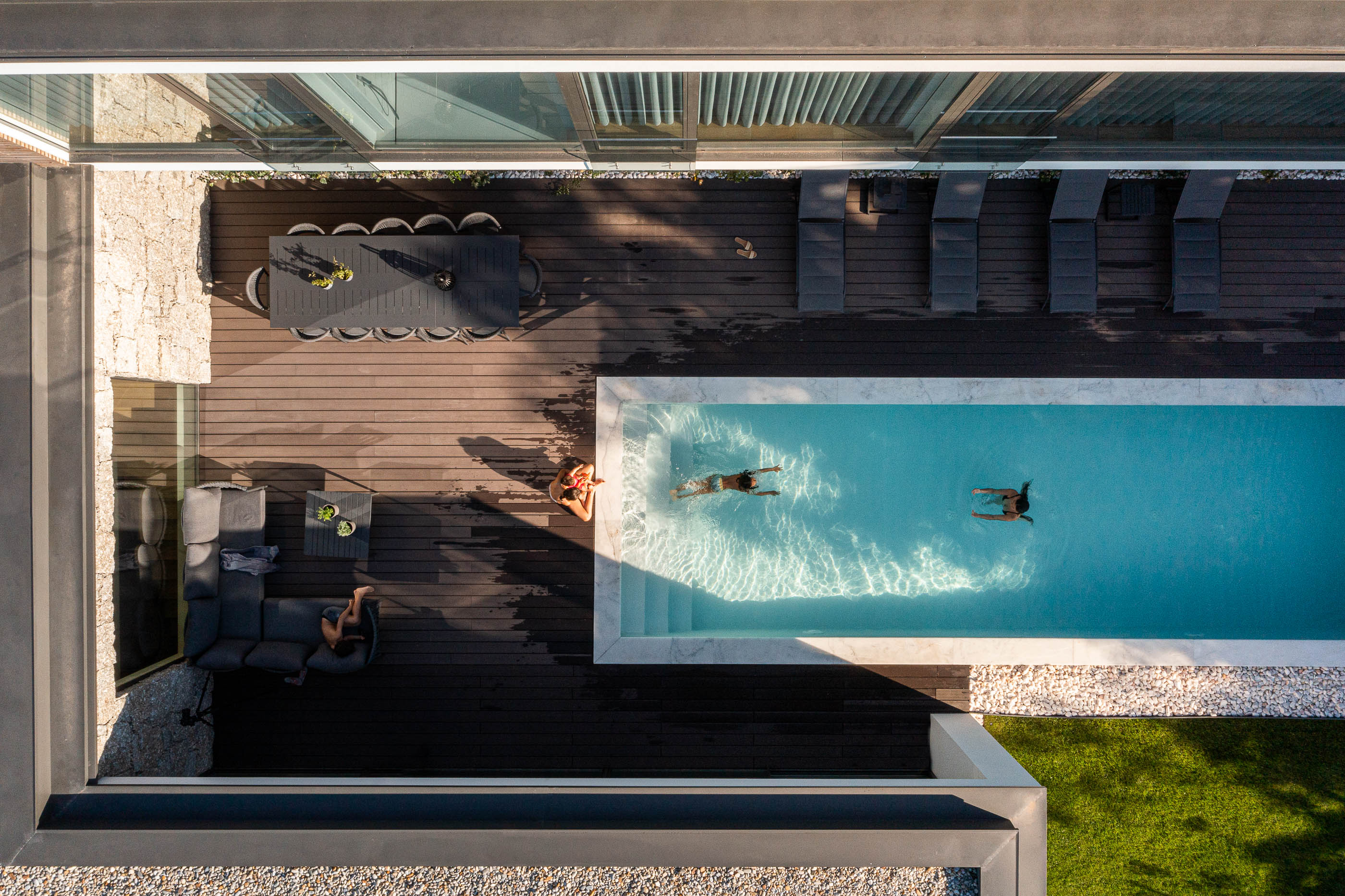 Exterior: Vista aérea da piscina com espreguiçadeiras, zona de refeições e jardim. — CASA [EN]COSTA arquitetura Hous3 em Guimarães