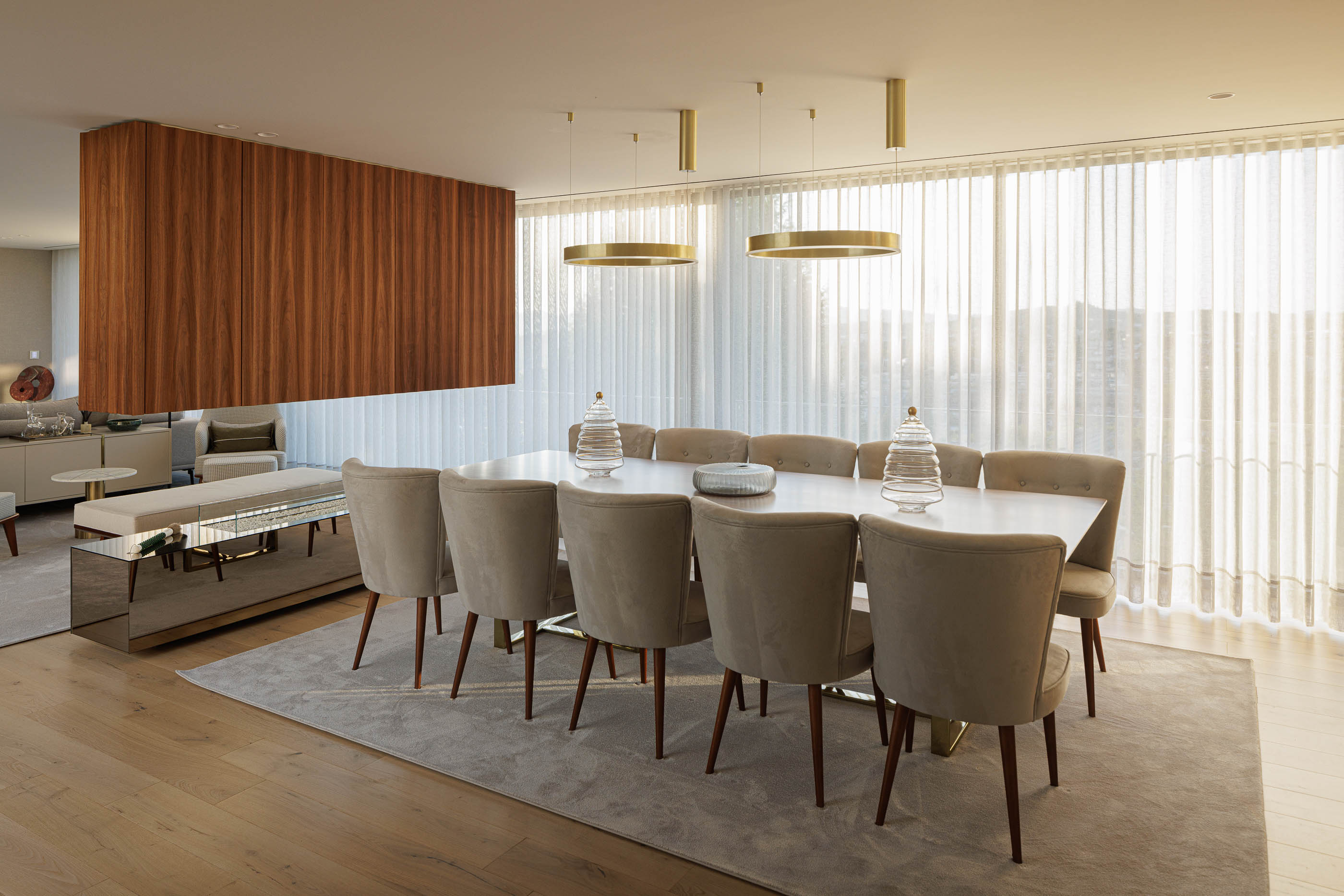 Sala de jantar: Mesa de jantar com tampo branco e cadeiras estofadas, com vista para a sala de estar. — CASA [EN]COSTA arquitetura Hous3 em Guimarães