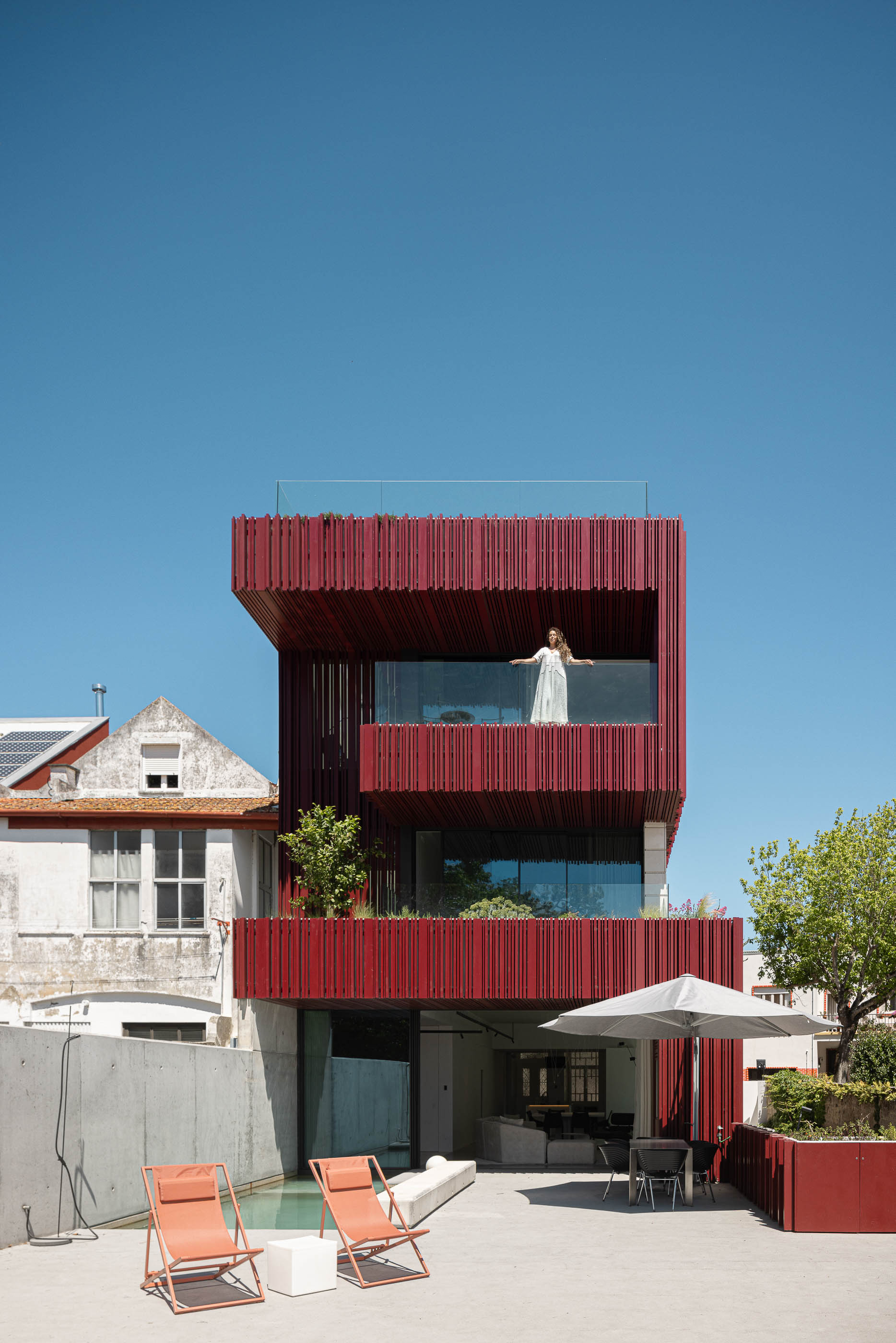 Exterior: Fachada posterior da casa com varandas, piscina, cadeiras de exterior e zona de refeições. — Casa do Parque arquitetura Paulo Martins Arquitectura e Design em Aveiro