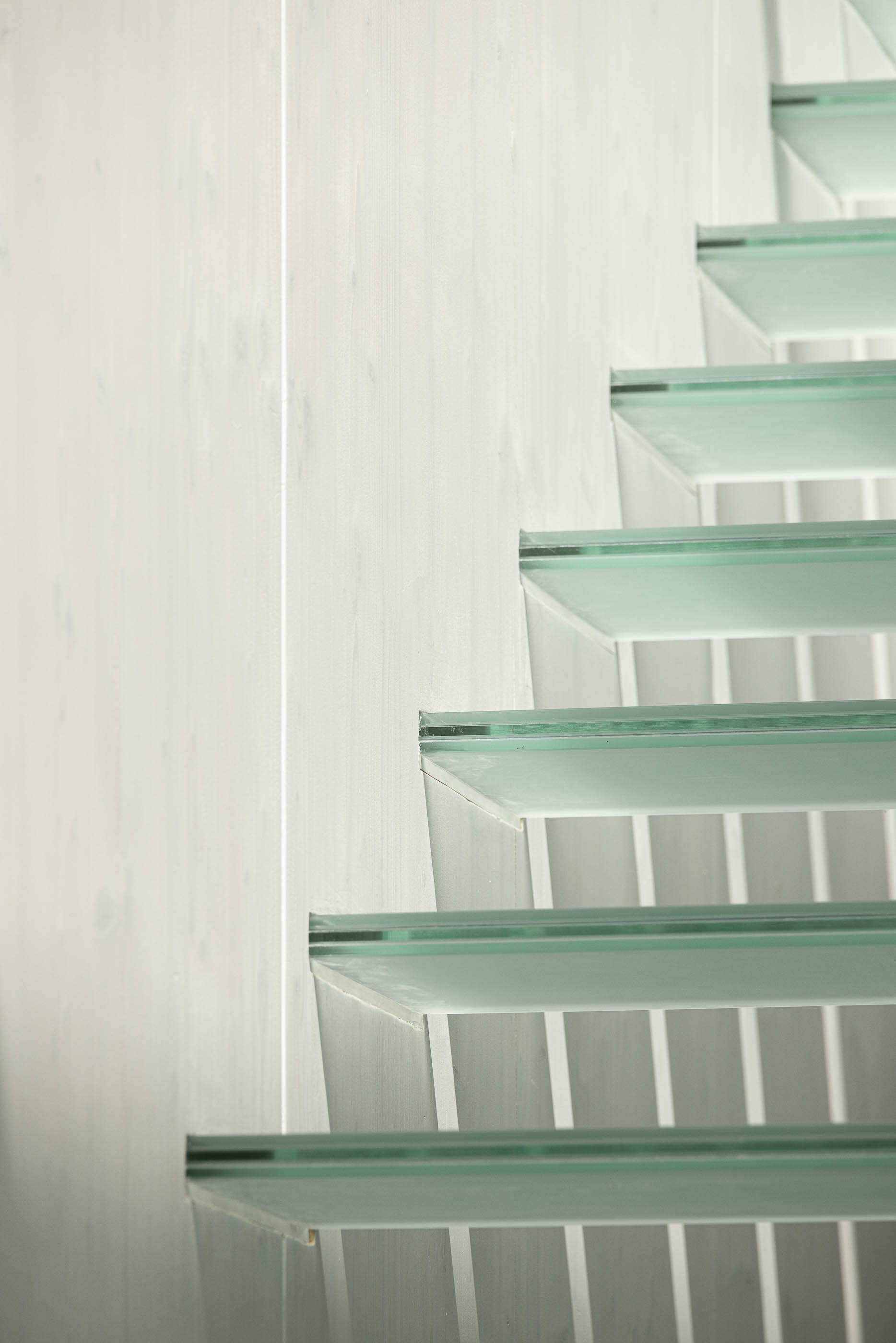 Escadas: Detalhe dos degraus em vidro, com estrutura de suporte branca. — Casa do Parque arquitetura Paulo Martins Arquitectura e Design em Aveiro