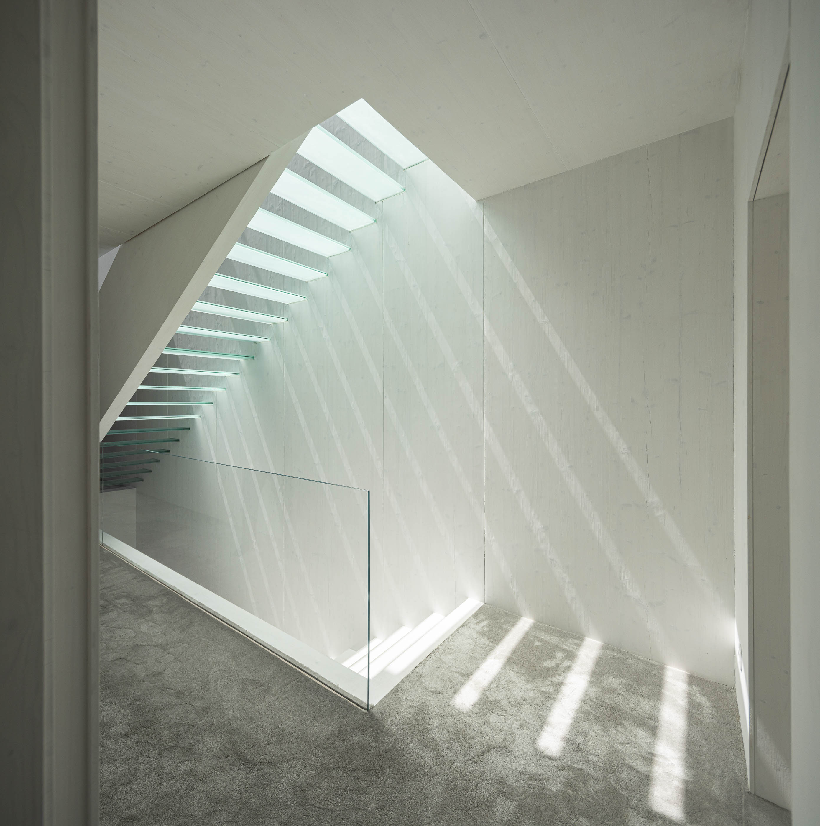 Escadas: Escadas com degraus em vidro, paredes brancas e alcatifa cinzenta no corredor. — Casa do Parque arquitetura Paulo Martins Arquitectura e Design em Aveiro