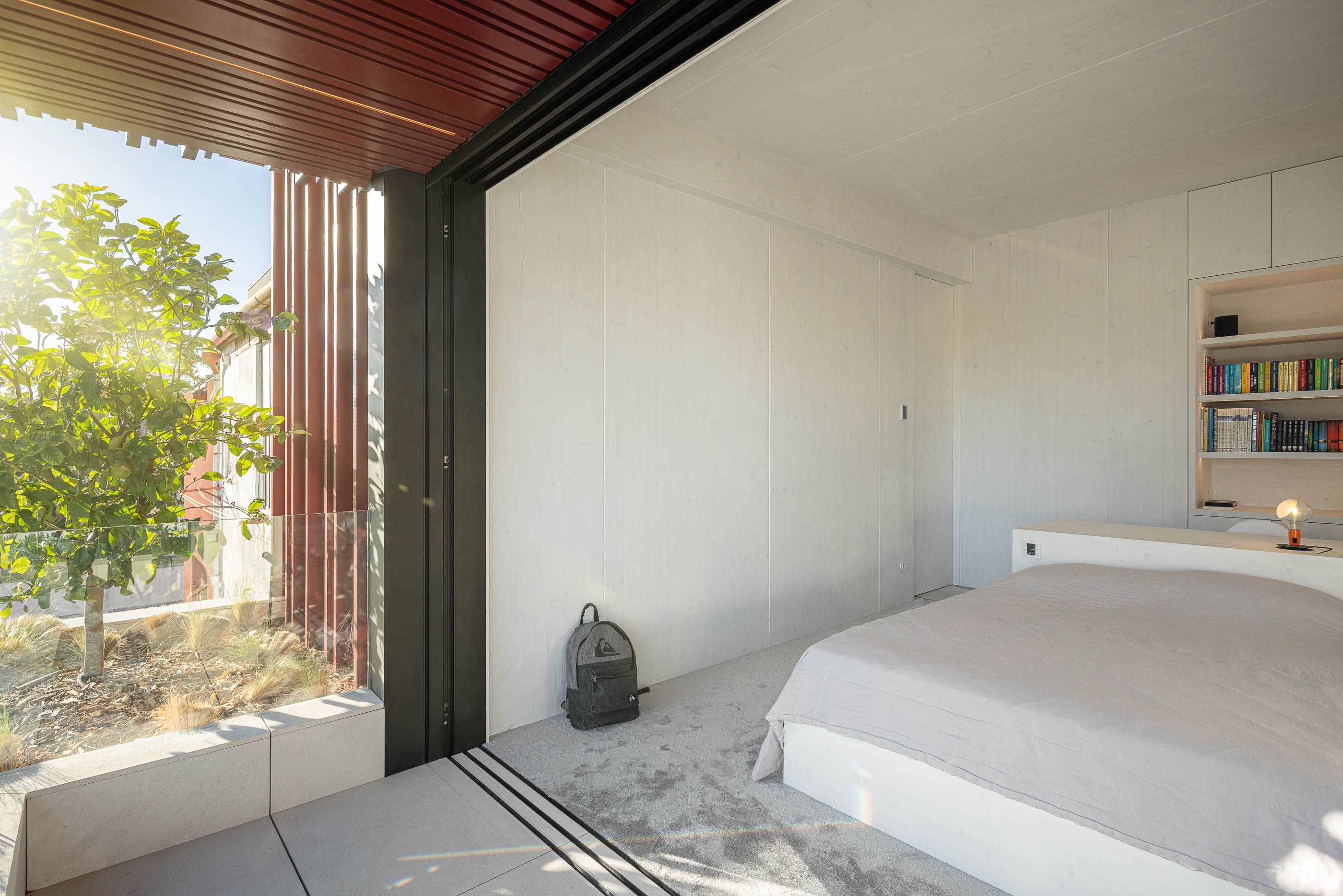 Quarto: Quarto com cama, secretária, estante e vista para o exterior através da janela. — Casa do Parque arquitetura Paulo Martins Arquitectura e Design em Aveiro