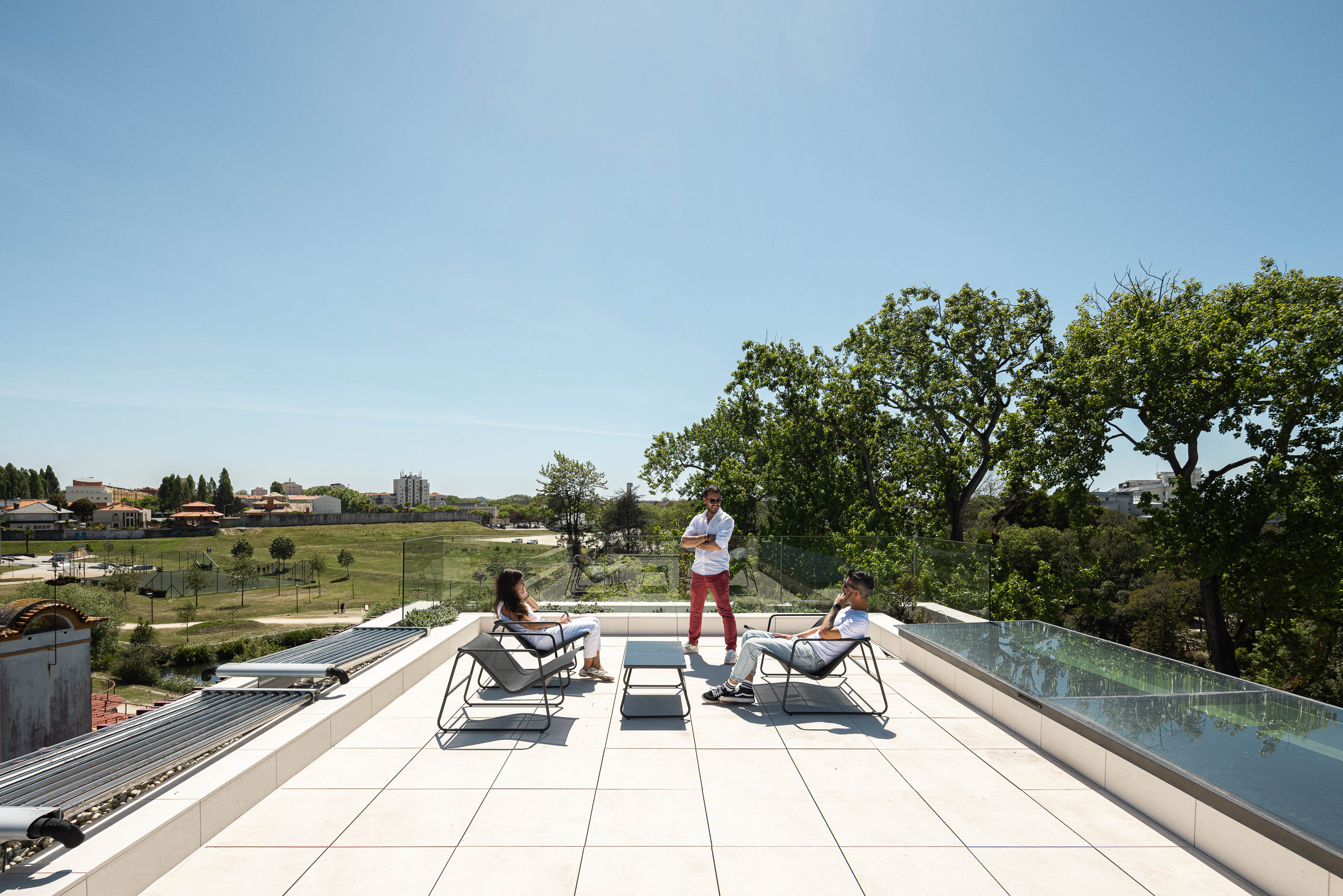 Terraço: Vista panorâmica do terraço com mobiliário de exterior e painéis solares. — Casa do Parque arquitetura Paulo Martins Arquitectura e Design em Aveiro