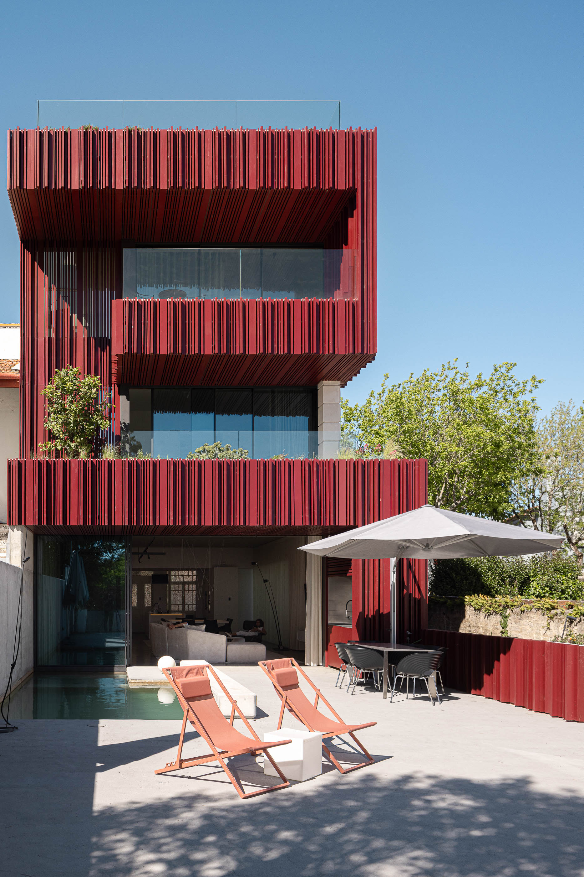 Exterior: Fachada posterior da casa com piscina, zona de refeições e área de descanso. — Casa do Parque arquitetura Paulo Martins Arquitectura e Design em Aveiro