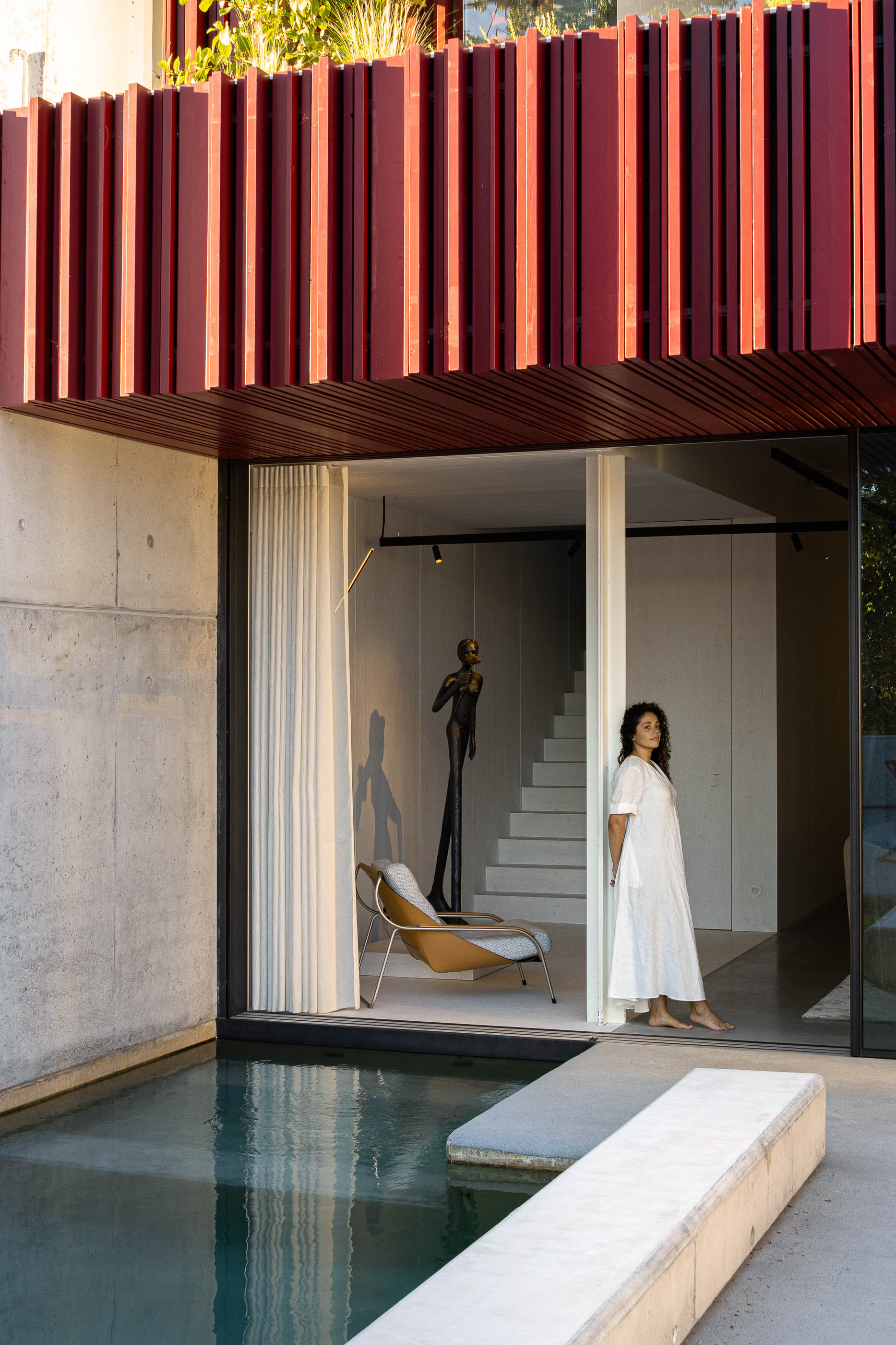 Exterior: Piscina com acesso ao interior da casa, escultura e zona de estar com cadeiras. — Casa do Parque arquitetura Paulo Martins Arquitectura e Design em Aveiro