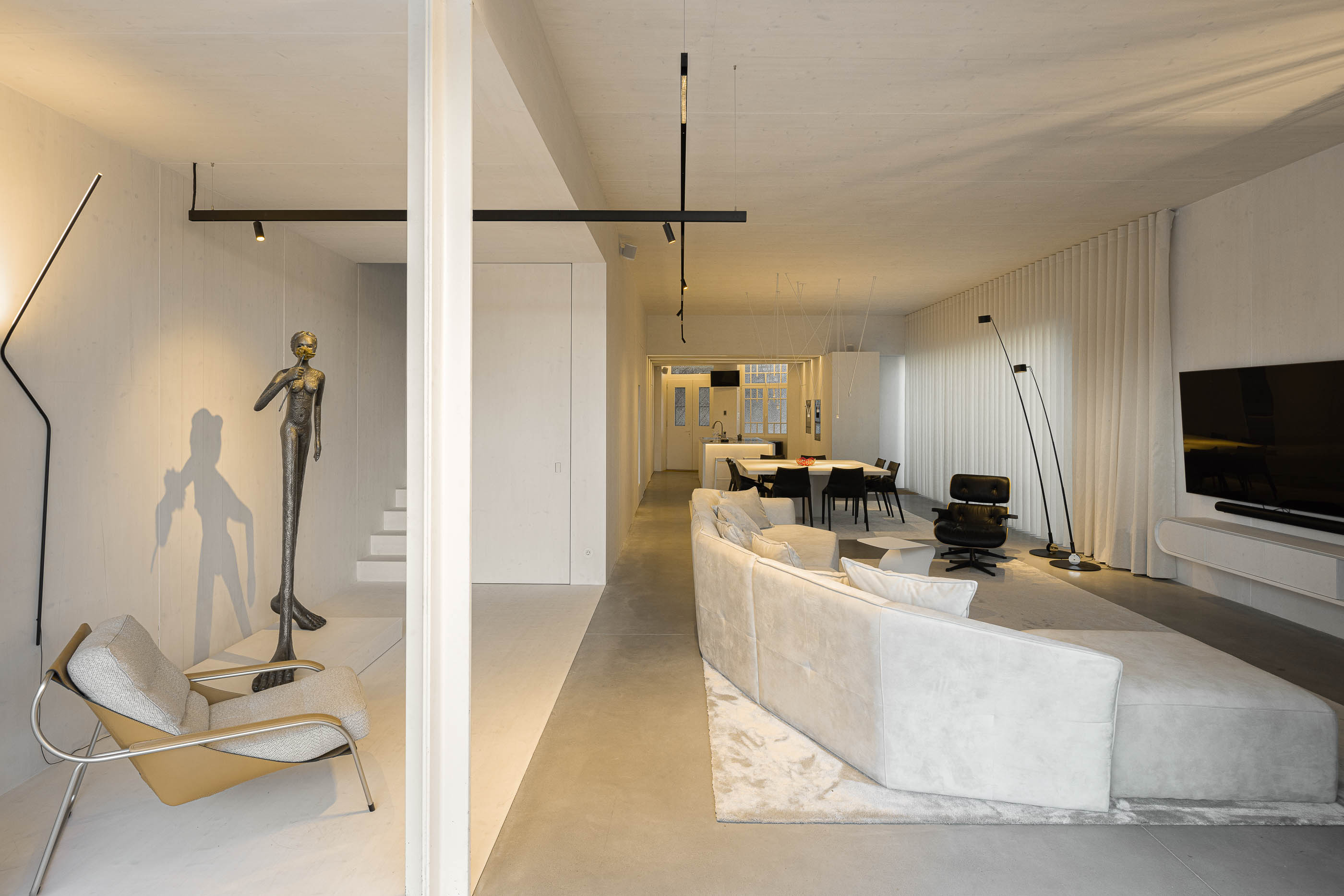 Sala de estar: Espaço amplo com sala de estar, sala de jantar e escadas, com decoração minimalista. — Casa do Parque arquitetura Paulo Martins Arquitectura e Design em Aveiro