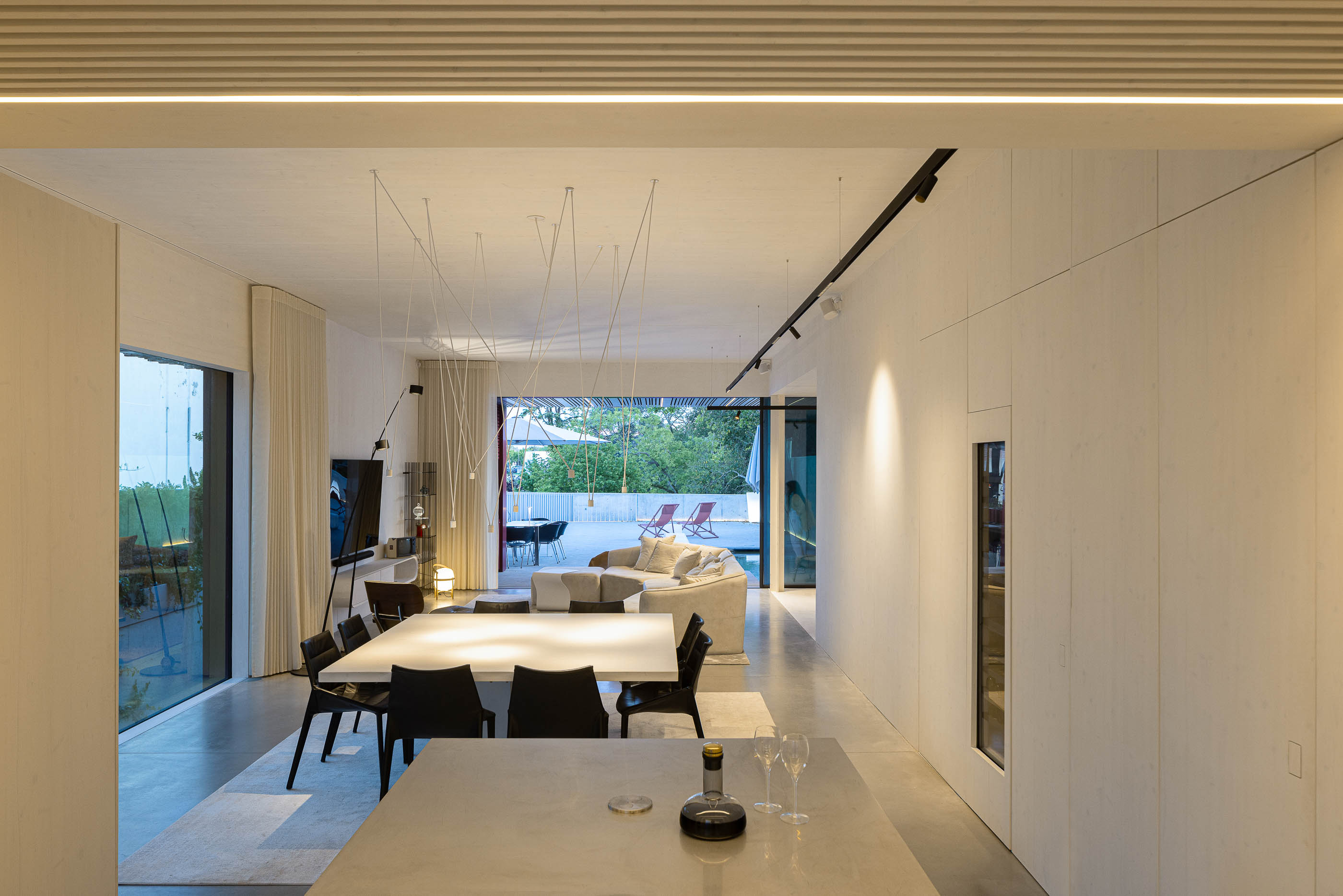 Sala de estar: Espaço amplo com sala de estar, sala de jantar e cozinha, com decoração minimalista. — Casa do Parque arquitetura Paulo Martins Arquitectura e Design em Aveiro