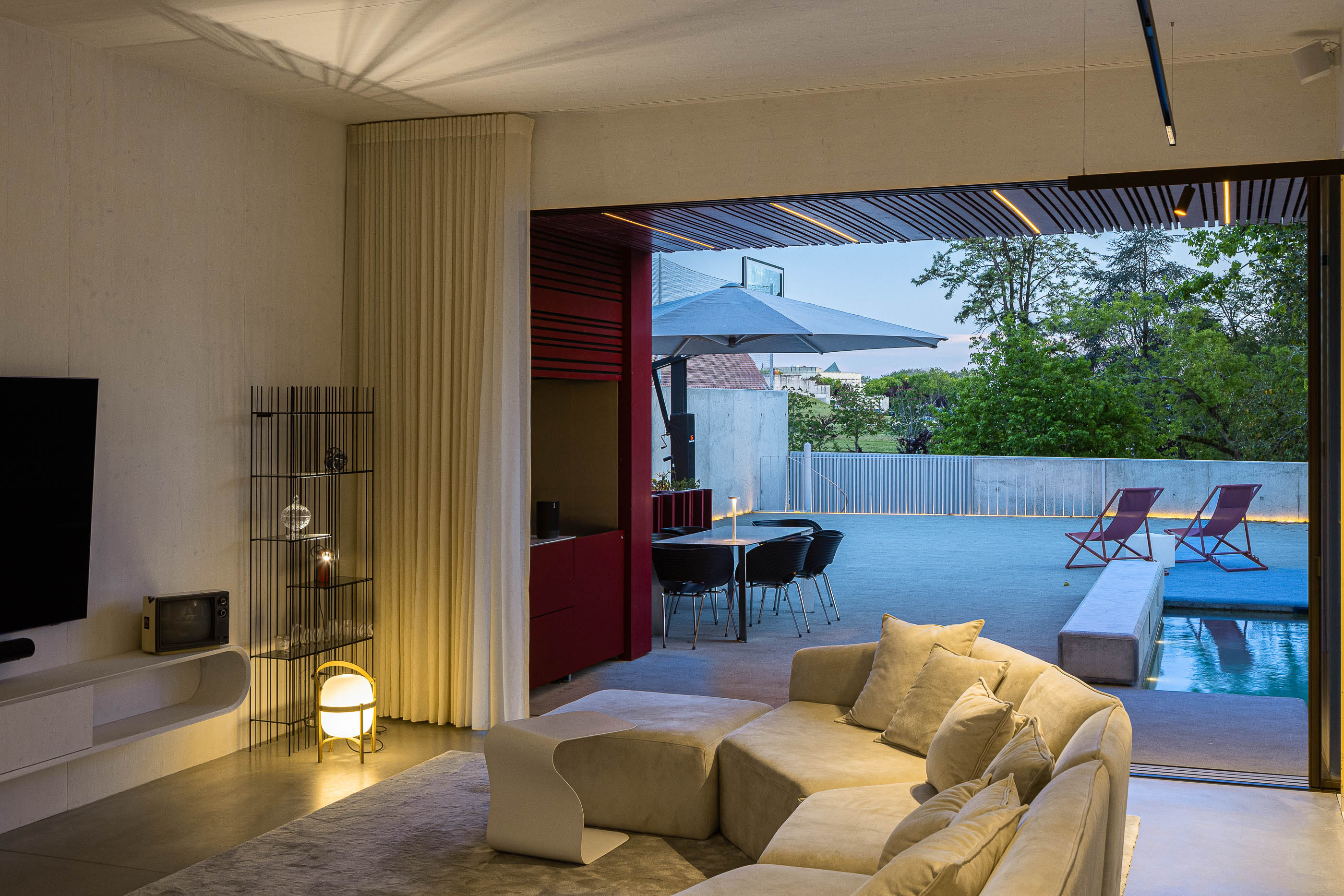 Sala de estar: Sofá bege, televisão, zona de refeições exterior e piscina. — Casa do Parque arquitetura Paulo Martins Arquitectura e Design em Aveiro