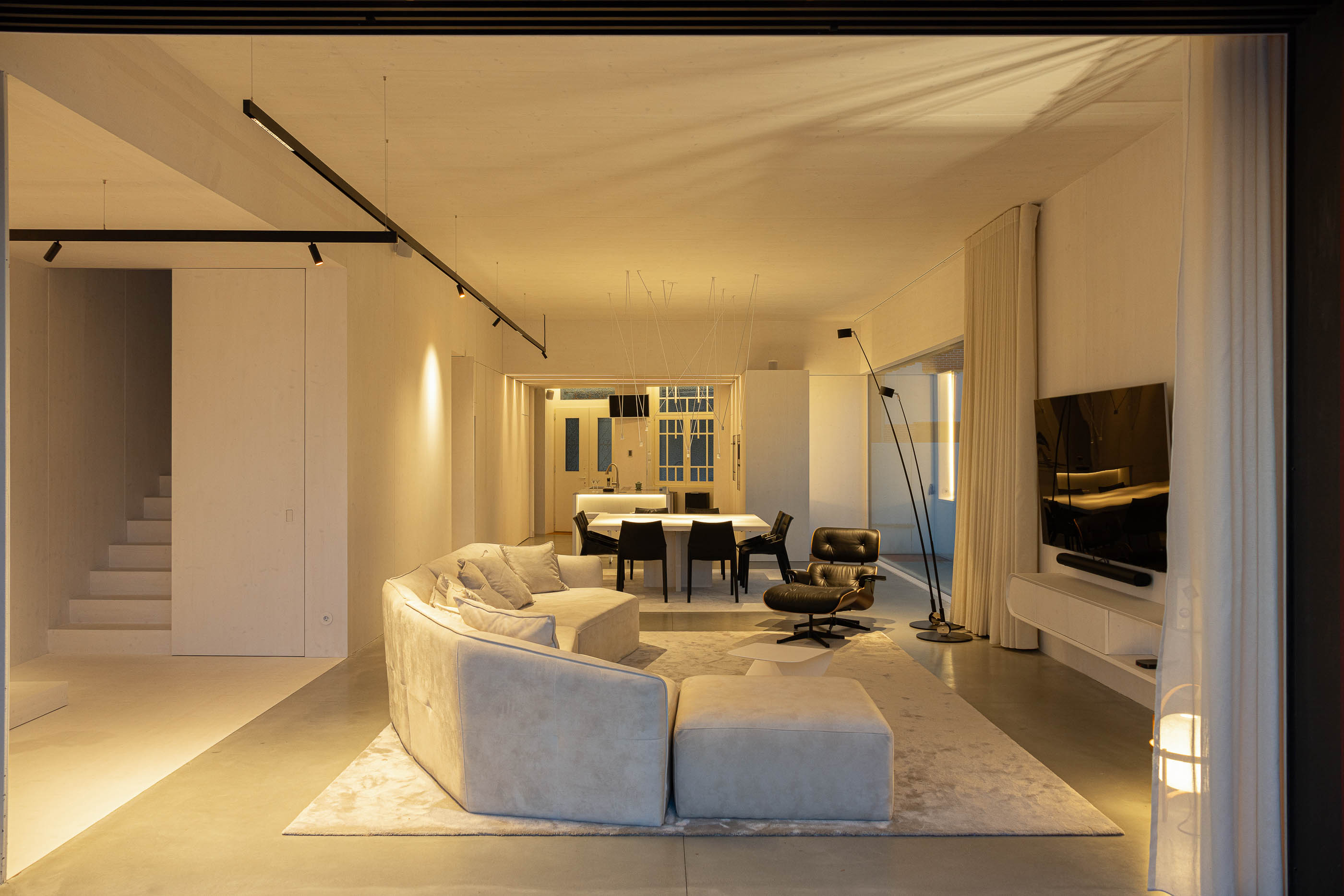 Sala de estar: Espaço amplo com sala de estar, sala de jantar e cozinha, com decoração minimalista. — Casa do Parque arquitetura Paulo Martins Arquitectura e Design em Aveiro