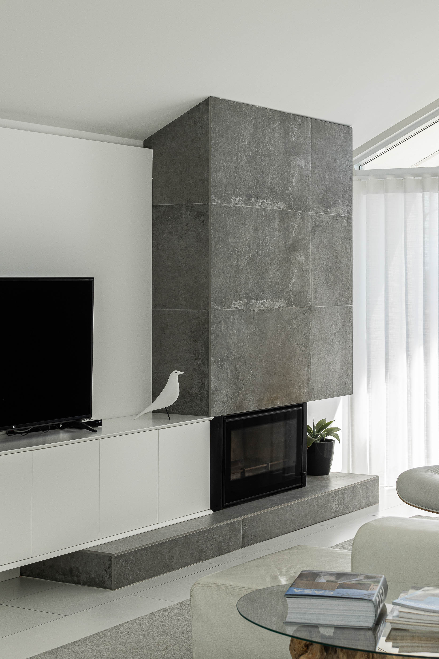 Sala de estar: Lareira revestida a pedra cinzenta, móvel branco e decoração minimalista. — Casa Cor de Sal arquitetura Rómulo Neto Arquitectos em Ílhavo