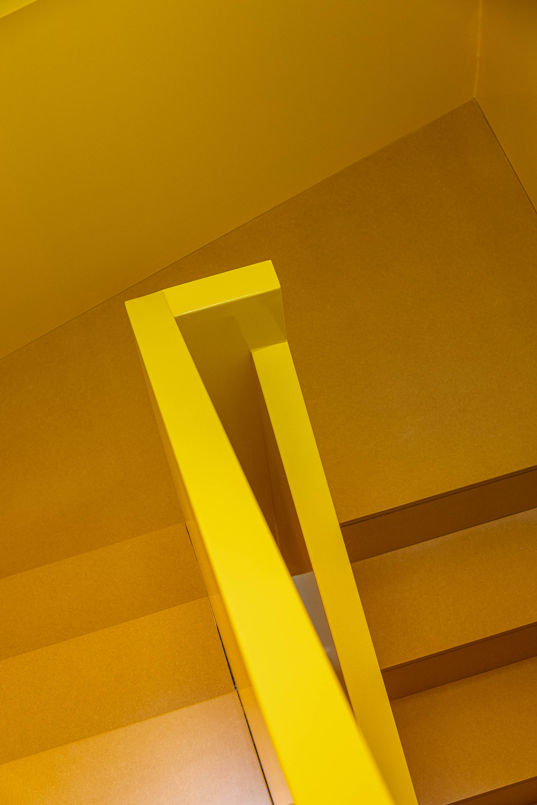 Escada: Detalhe do corrimão amarelo da escada, com pavimento em madeira clara. — A'mar arquitetura REM'A Arquitectos em Póvoa de Varzim