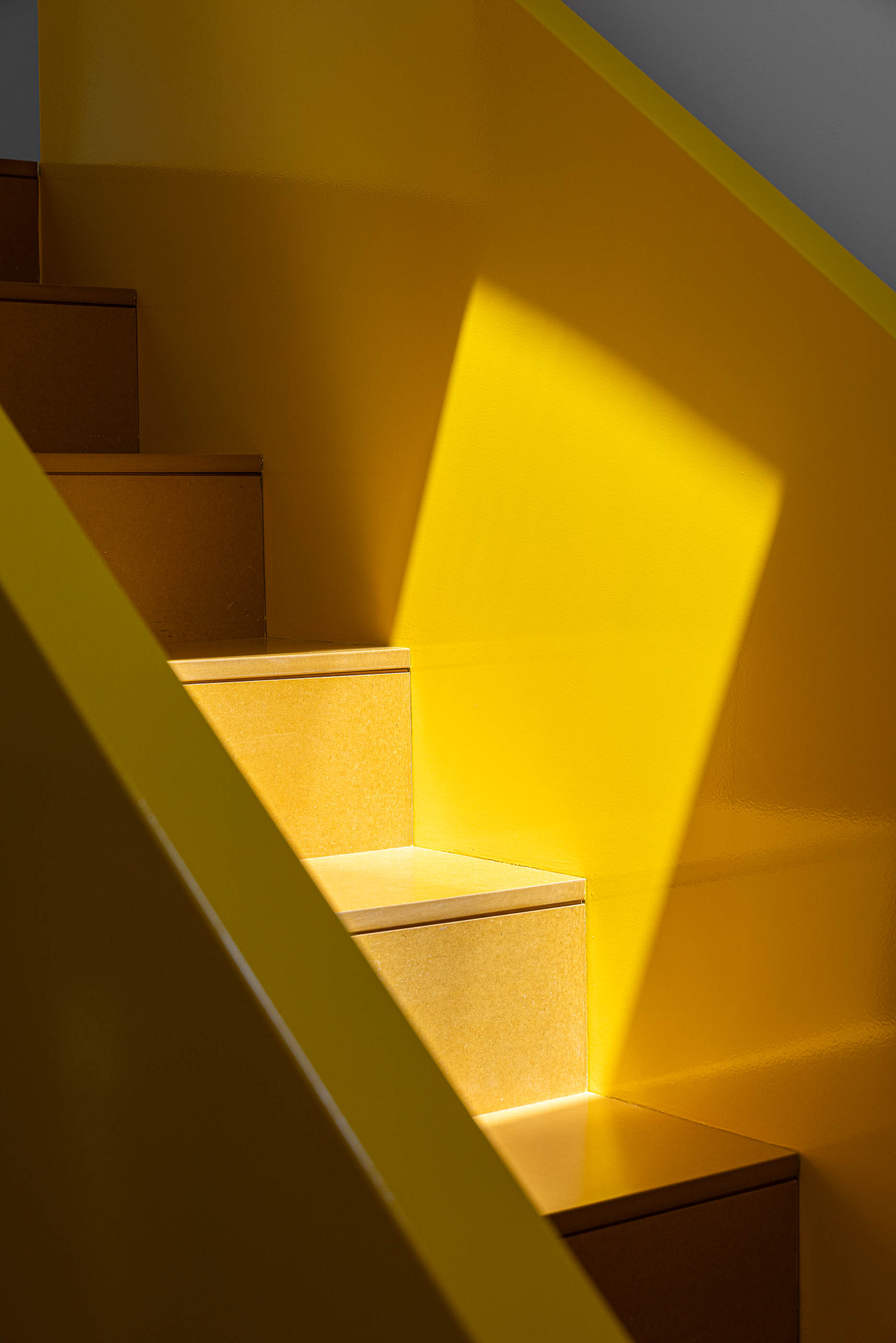 Escada: Pormenor da escada amarela, com degraus em madeira clara e luz natural. — A'mar arquitetura REM'A Arquitectos em Póvoa de Varzim