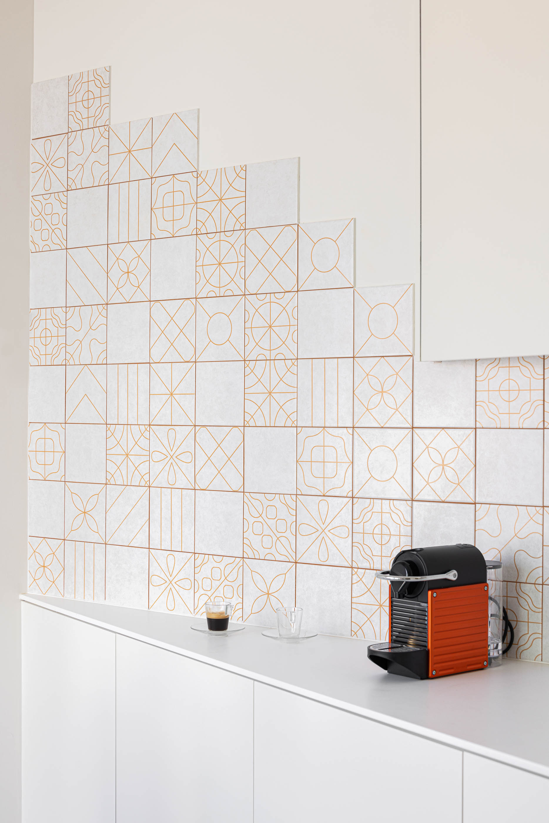 Cozinha: Detalhe do revestimento cerâmico decorado na parede da cozinha, com máquina de café. — A'mar arquitetura REM'A Arquitectos em Póvoa de Varzim