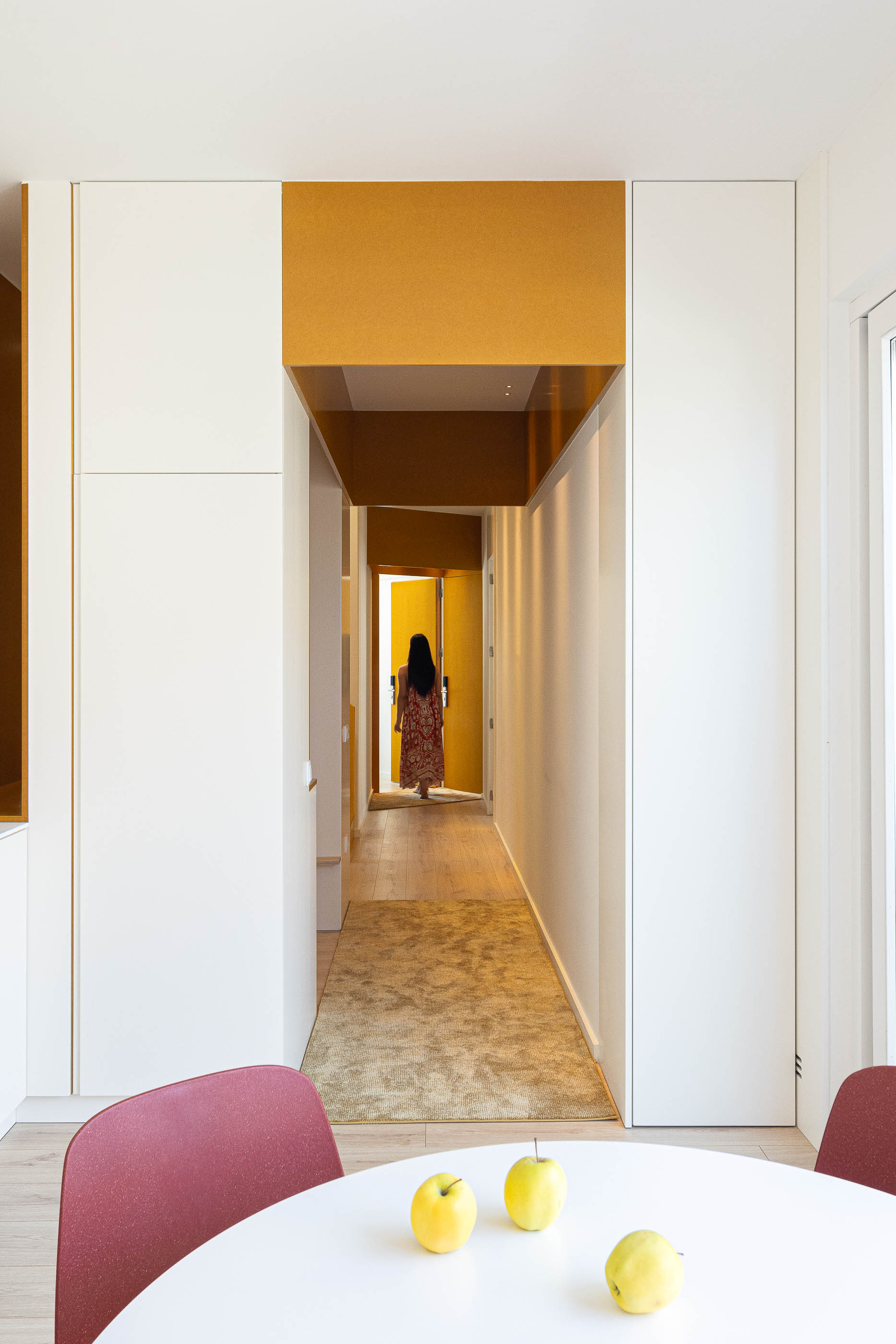 Corredor: Corredor com alcatifa, armários brancos e detalhes em amarelo. — A'mar arquitetura REM'A Arquitectos em Póvoa de Varzim