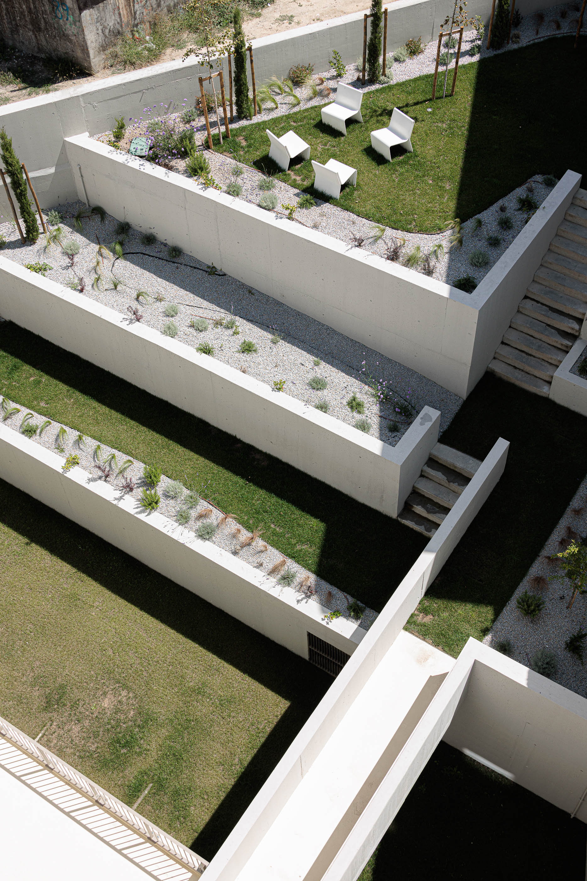 Jardim: Vista aérea do jardim com relvado, seixo, vegetação e mobiliário branco. — Varandas de Salgueiros arquitetura Floret Arquitectura em Porto
