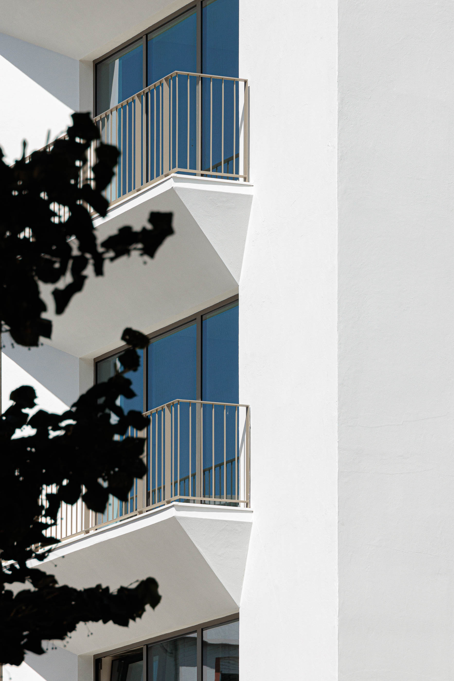 Detalhe: Varandas triangulares com guardas metálicas e reflexos nos vidros. — Varandas de Salgueiros arquitetura Floret Arquitectura em Porto