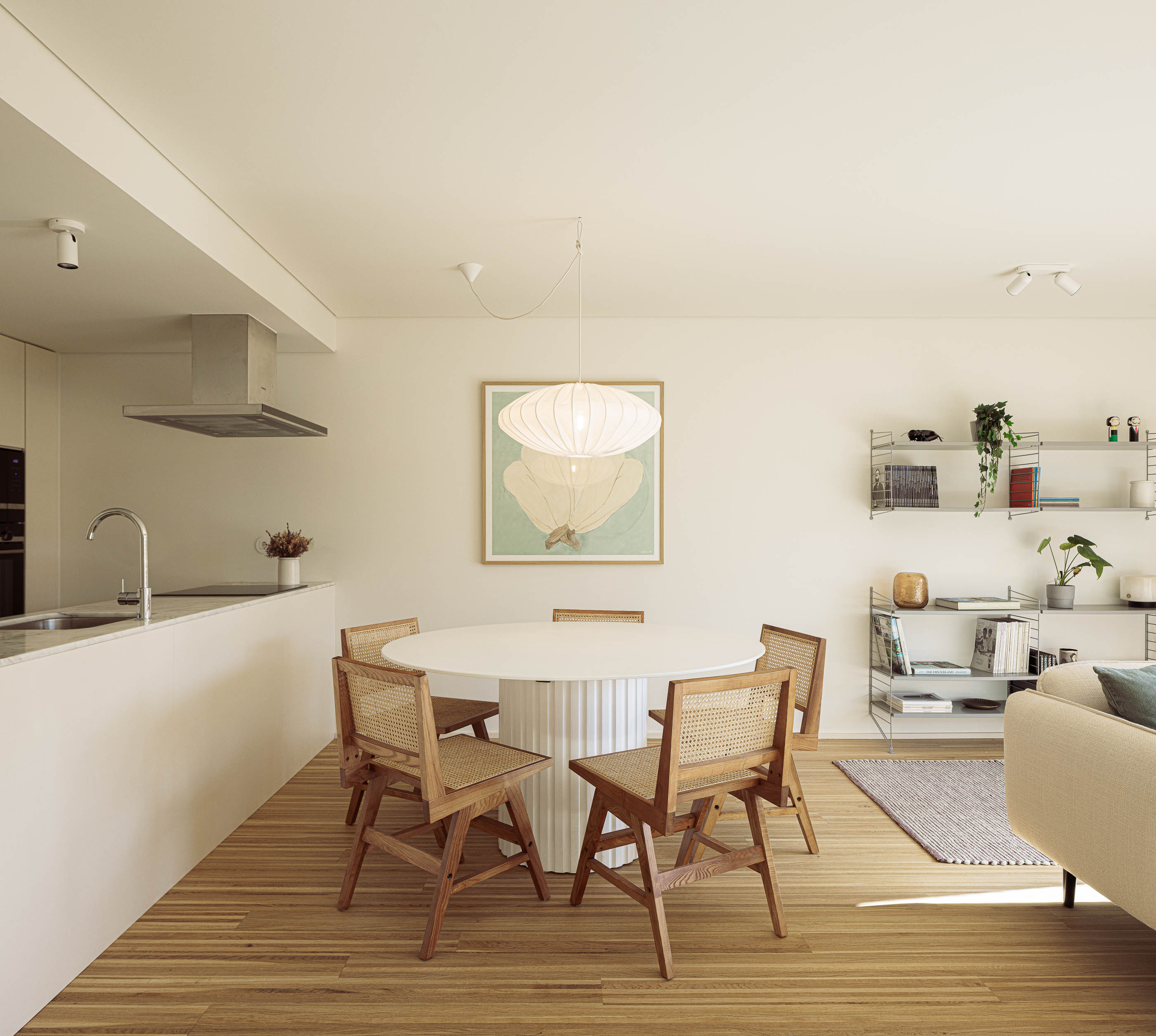 Sala de estar: Sala de estar com cozinha integrada, mesa de jantar redonda e cadeiras de palhinha. — Varandas de Salgueiros arquitetura Floret Arquitectura em Porto