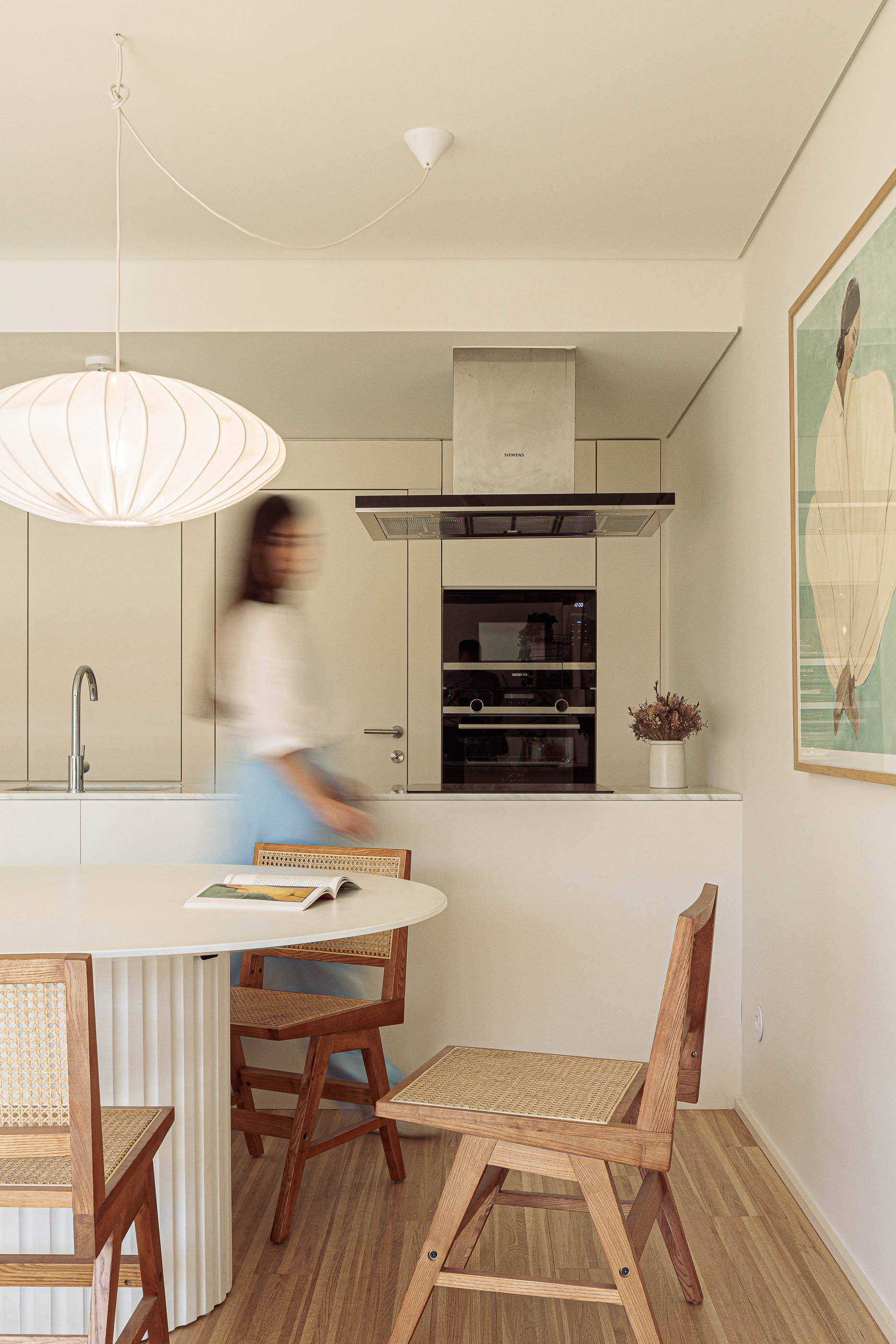 Cozinha: Mesa de jantar redonda com cadeiras de palhinha e cozinha minimalista branca. — Varandas de Salgueiros arquitetura Floret Arquitectura em Porto