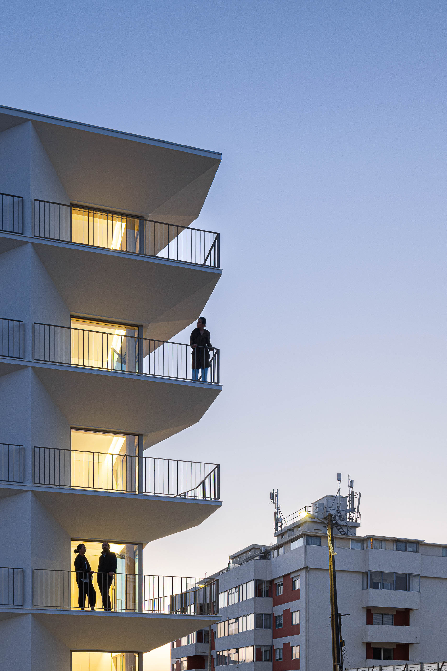 Exterior: Detalhe das varandas triangulares iluminadas ao entardecer. — Varandas de Salgueiros arquitetura Floret Arquitectura em Porto