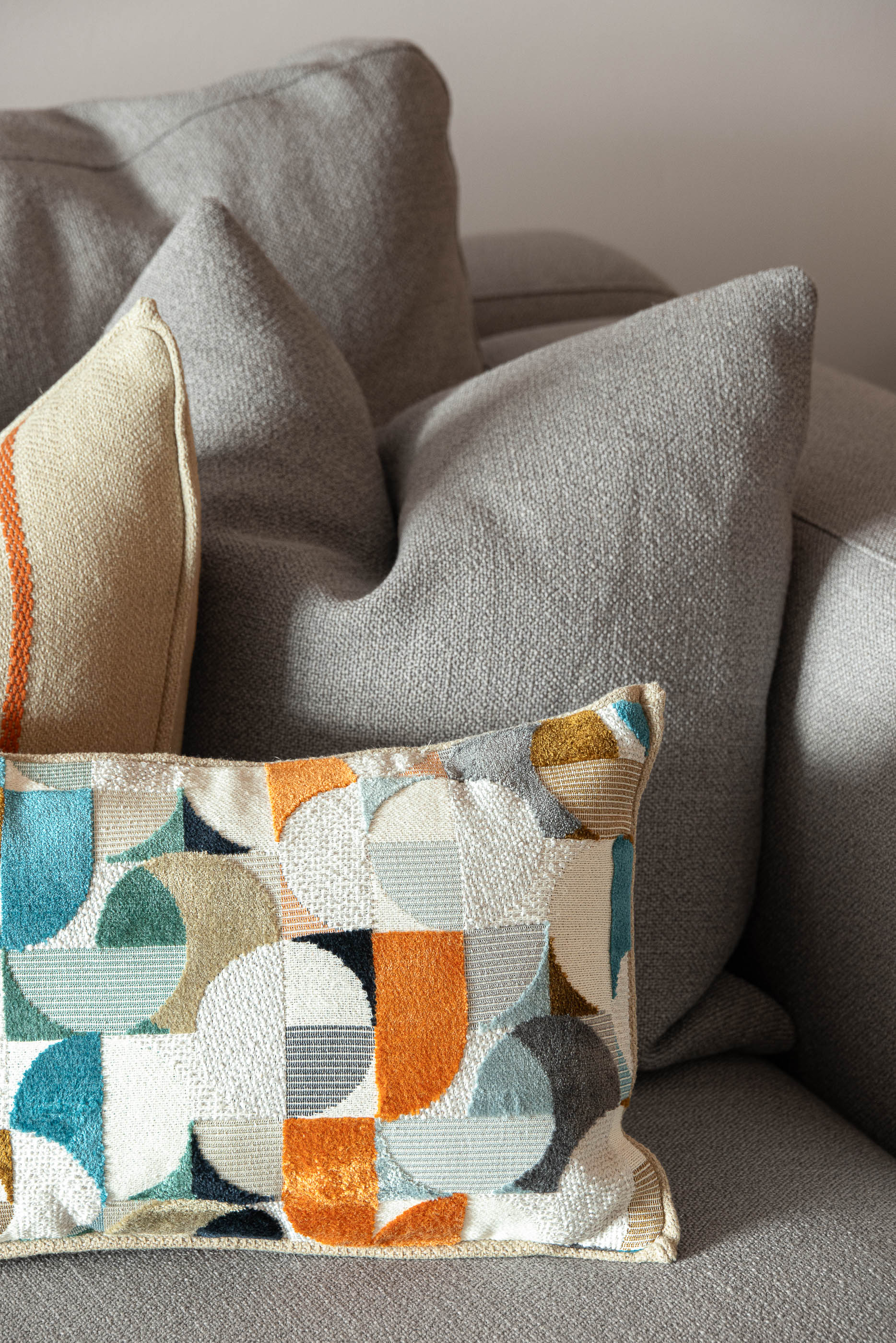 Sala de estar, detalhe de almofadas decorativas no sofá cinzento com textura. — Reforma apartamento CP em Avilés arquitetura David Olmos Arquitectos em Avilés
