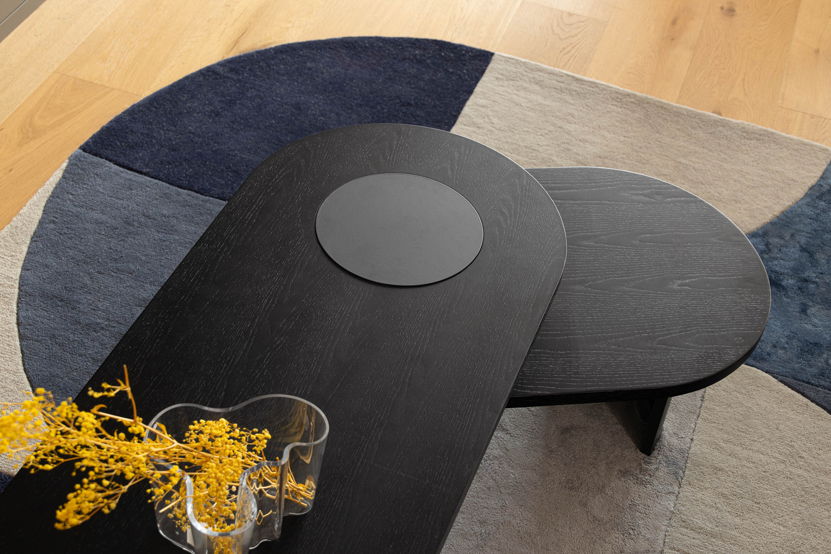 Sala de estar, detalhe da mesa de centro preta e alcatifa geométrica sobre pavimento de madeira clara. — Reforma apartamento CP em Avilés arquitetura David Olmos Arquitectos em Avilés
