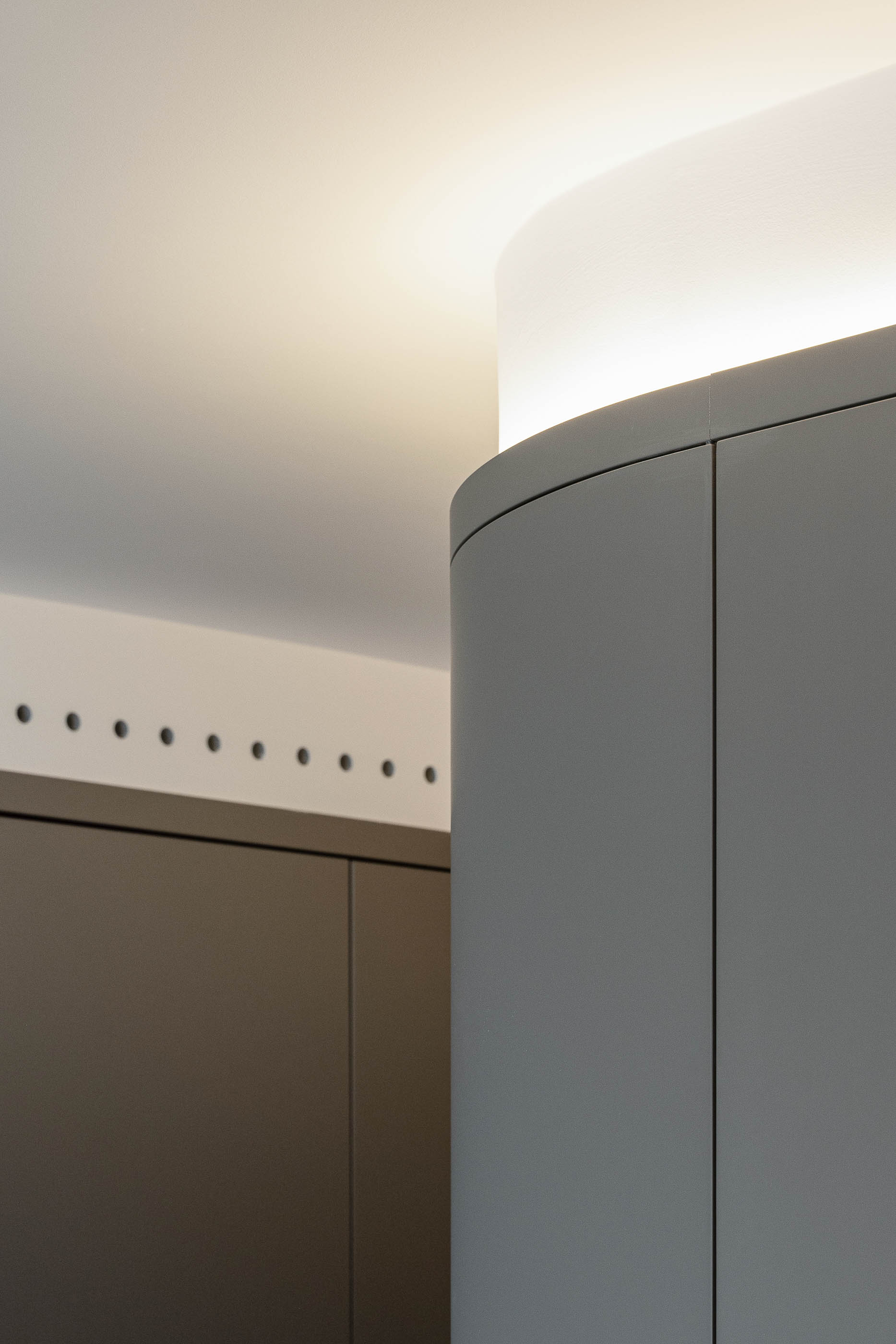 Corredor, detalhe do teto curvo com iluminação e móvel cinzento. — Reforma apartamento CP em Avilés arquitetura David Olmos Arquitectos em Avilés