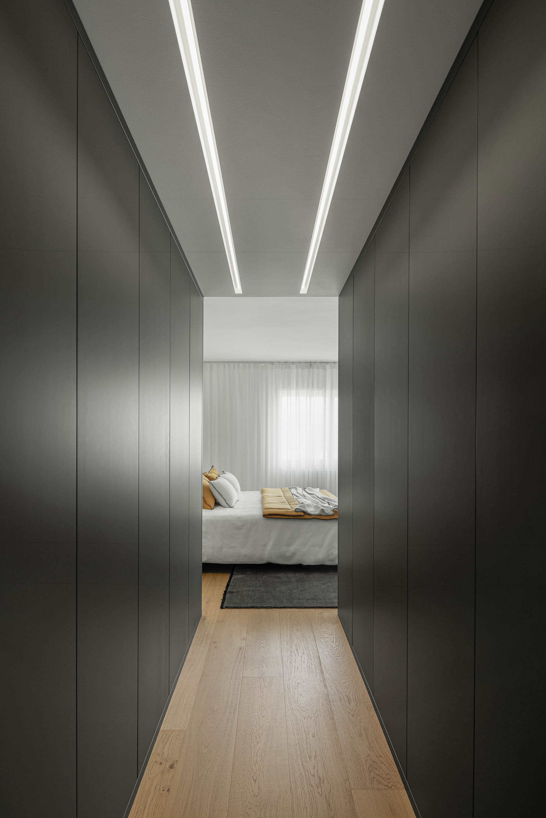 Quarto, vista do roupeiro cinzento embutido para a cama. Pavimento em madeira clara. — Reforma apartamento CP em Avilés arquitetura David Olmos Arquitectos em Avilés