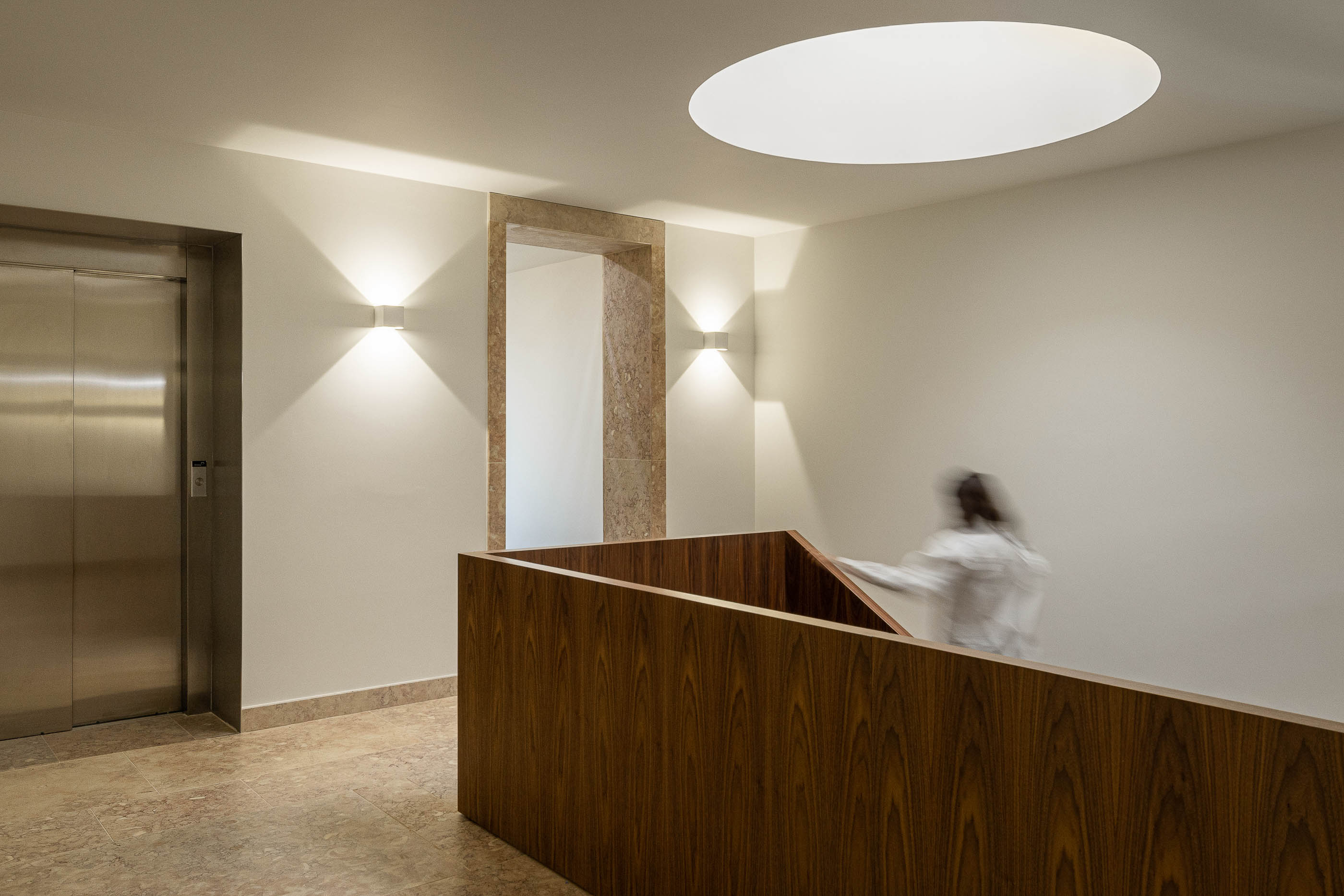 Escadas: Elevador em aço inoxidável, paredes brancas e pavimento em mármore. — Condomínio das Artes arquitetura MiMool Arquitectura & Interiores em Porto
