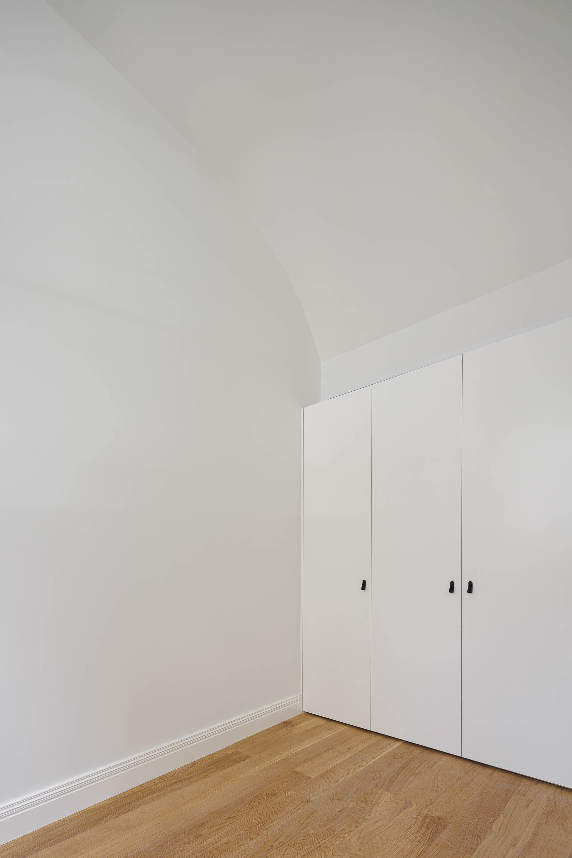 Quarto: Roupeiro branco embutido, paredes brancas e pavimento em madeira clara. — Condomínio das Artes arquitetura MiMool Arquitectura & Interiores em Porto