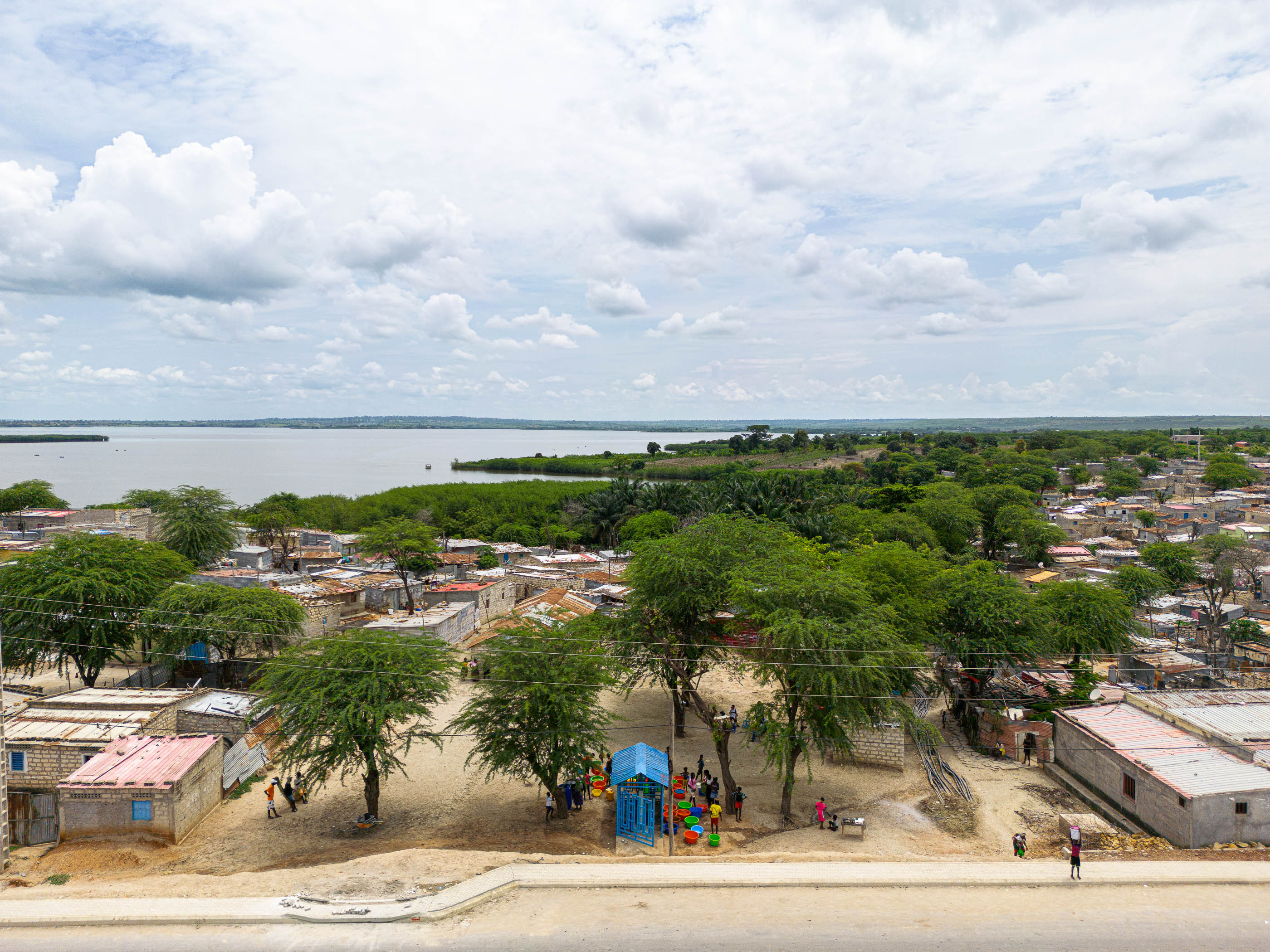 Paisagem: Vista aérea de Luanda, com casas, árvores, lago e um parque infantil azul. — Chafarizes em Luanda arquitetura Paulo Moreira Architectures em Luanda