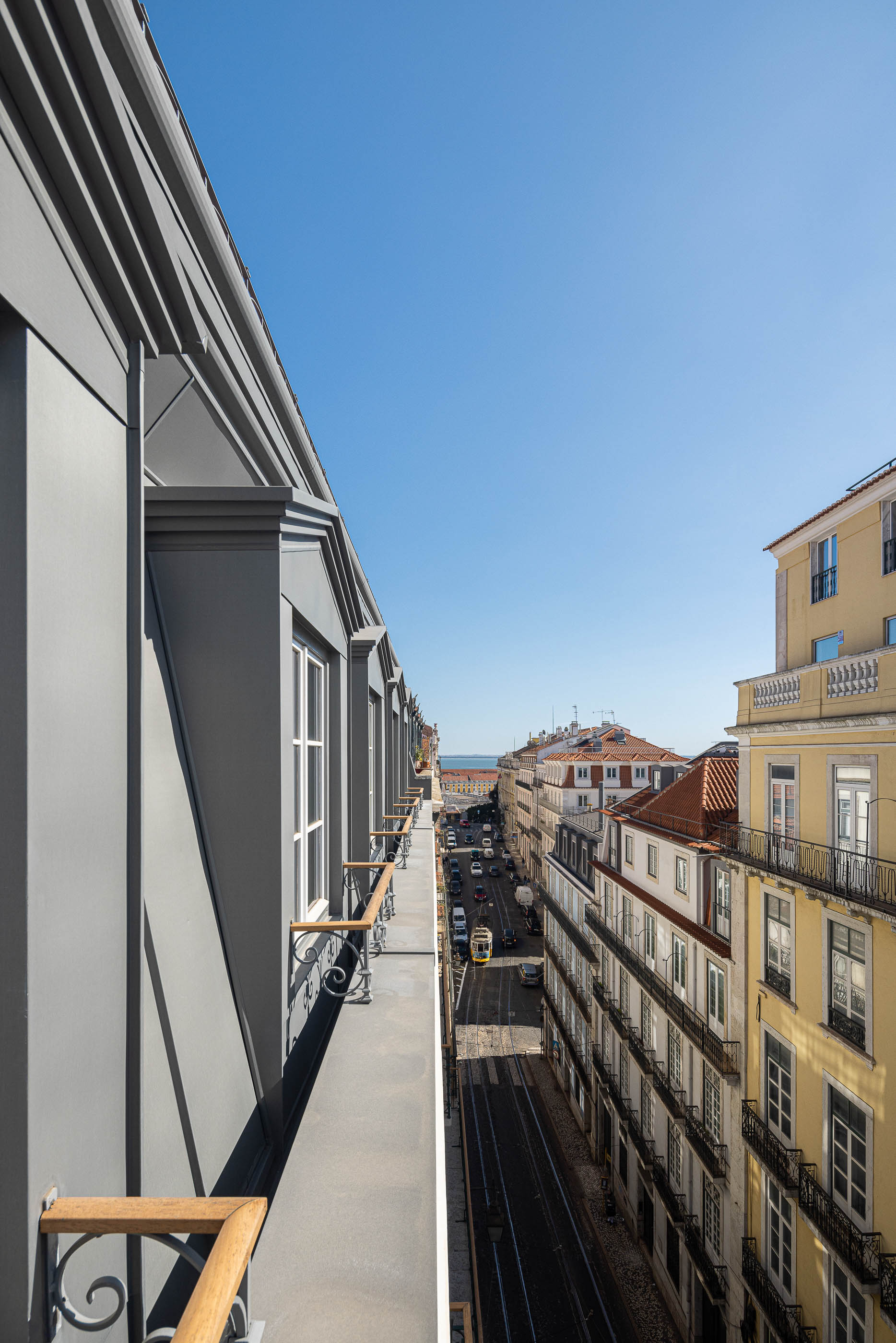 Varanda: Vista panorâmica da rua a partir da varanda com gradeamento em ferro forjado e pavimento cinzento. — Victor Cordon arquitetura Fragmentos em Lisboa