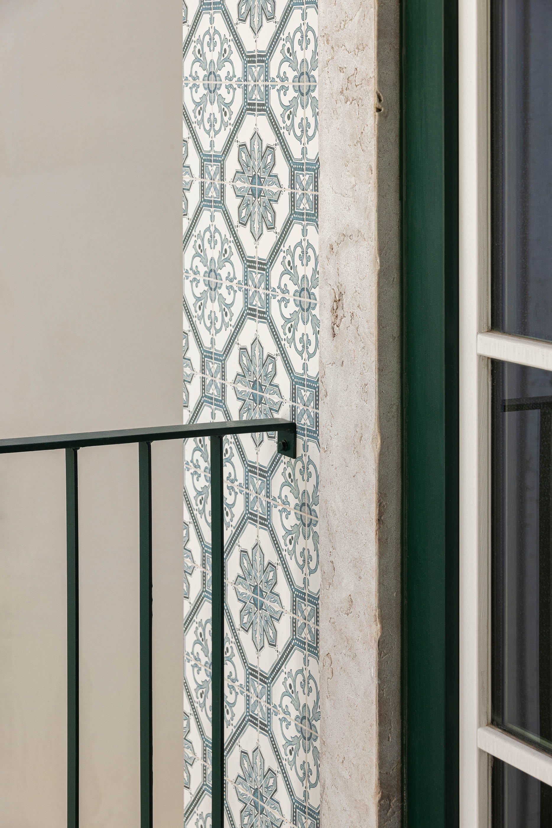 Varanda: Detalhe dos azulejos decorativos, gradeamento em ferro forjado e caixilharia verde. — Victor Cordon arquitetura Fragmentos em Lisboa