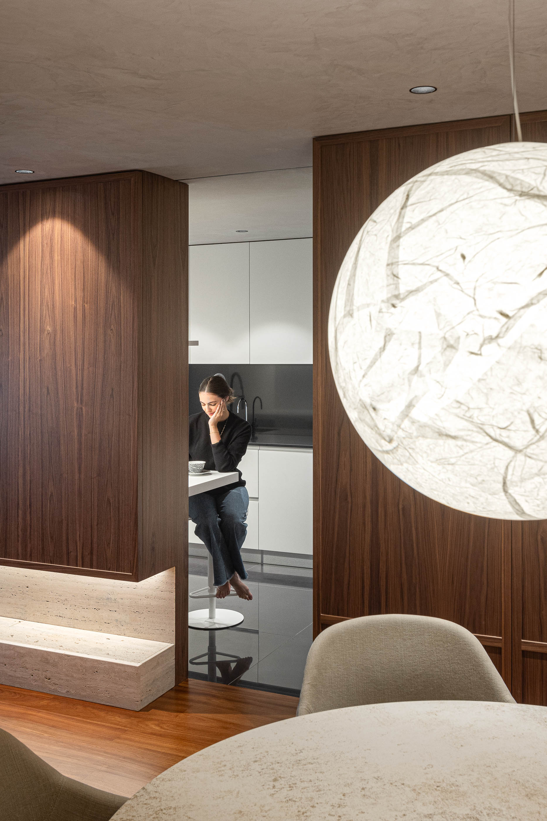 Sala de jantar: Vista da mesa de jantar para a cozinha, com balcão alto e armários brancos. — Lugar Comum arquitetura edmundo* architecture + planning em vila do conde