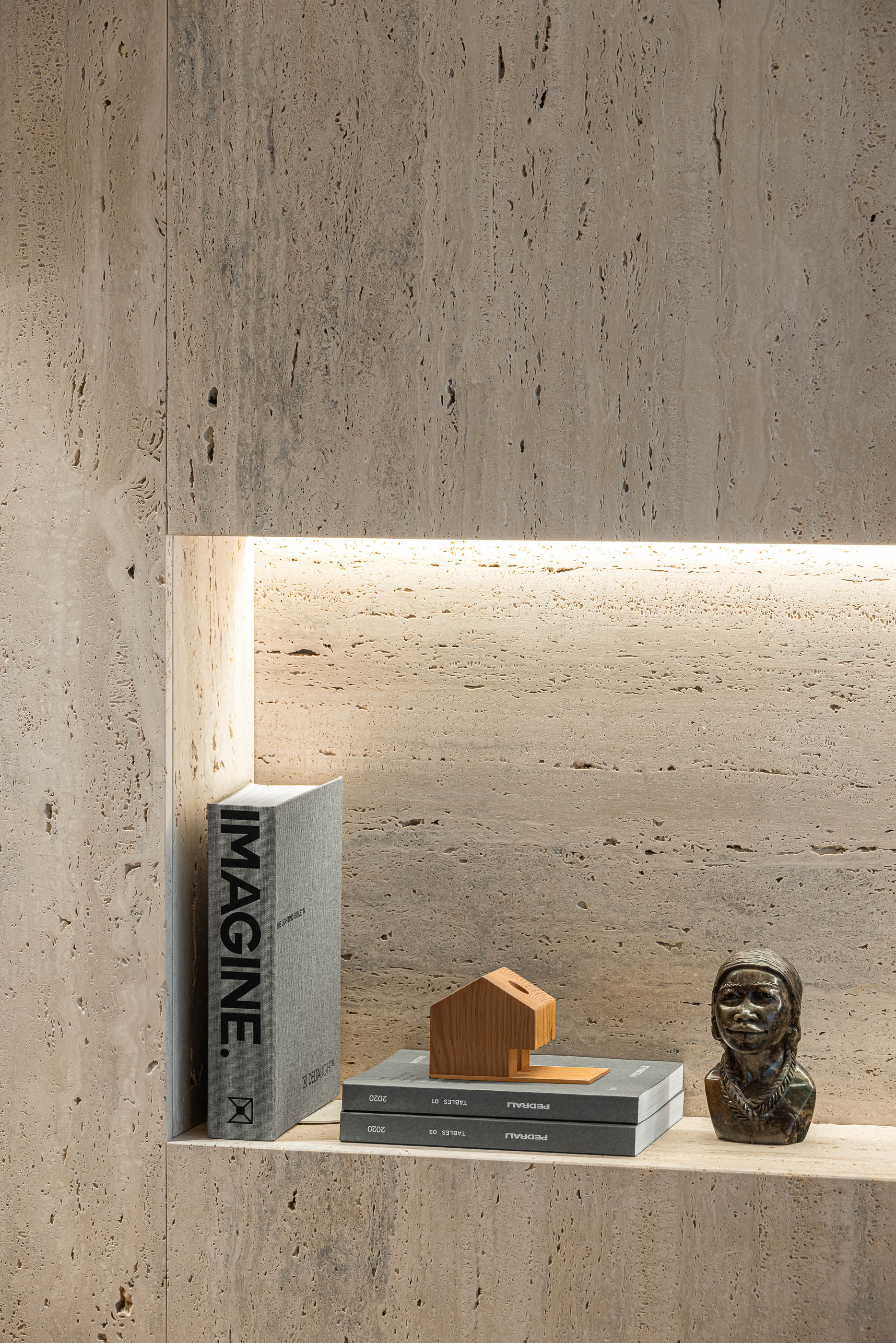 Sala de estar: Detalhe de nicho em travertino com iluminação embutida e objetos decorativos. — Lugar Comum arquitetura edmundo* architecture + planning em vila do conde