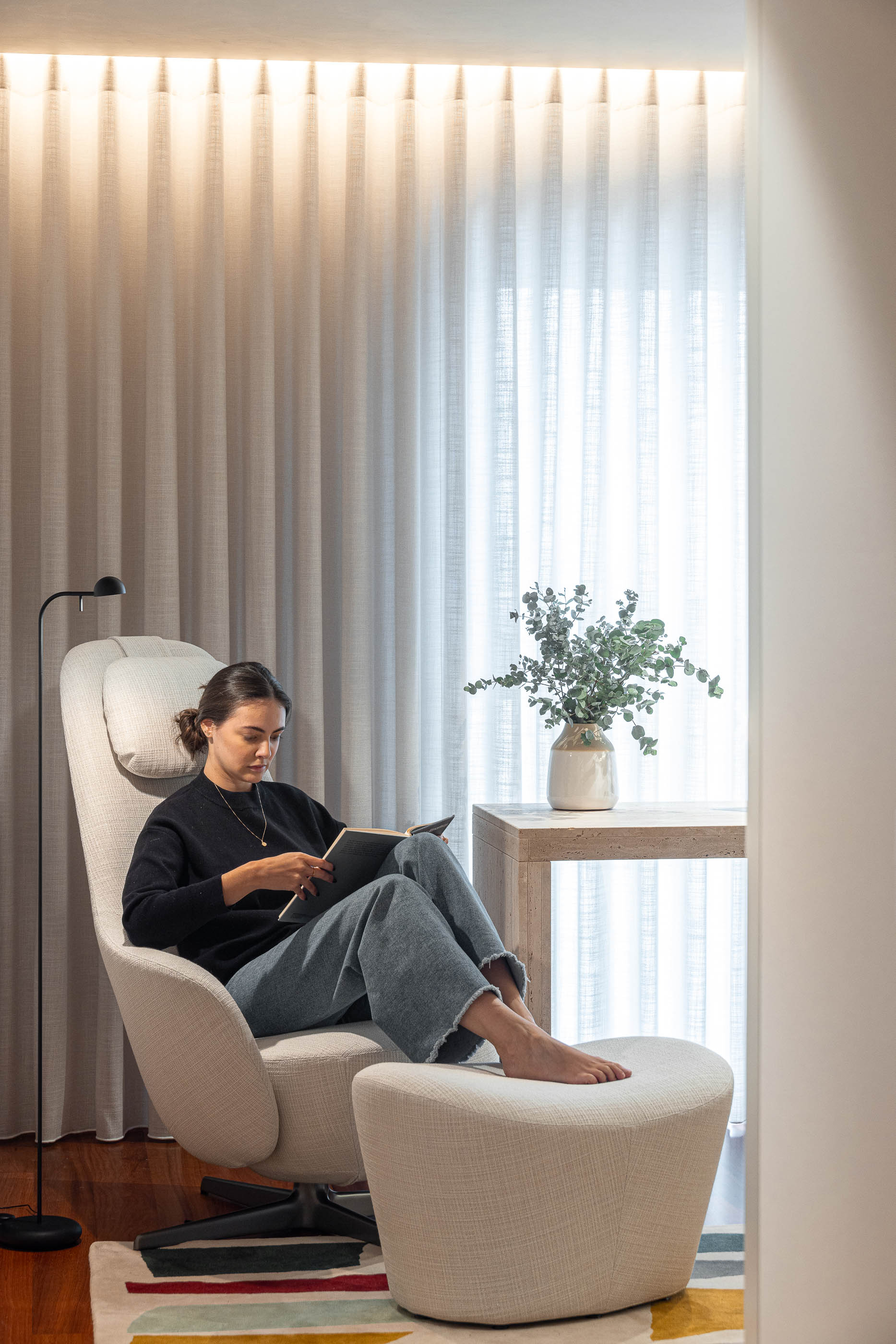 Escritório: Cadeira de braços e candeeiro de pé junto à janela com cortinas claras. — Lugar Comum arquitetura edmundo* architecture + planning em vila do conde