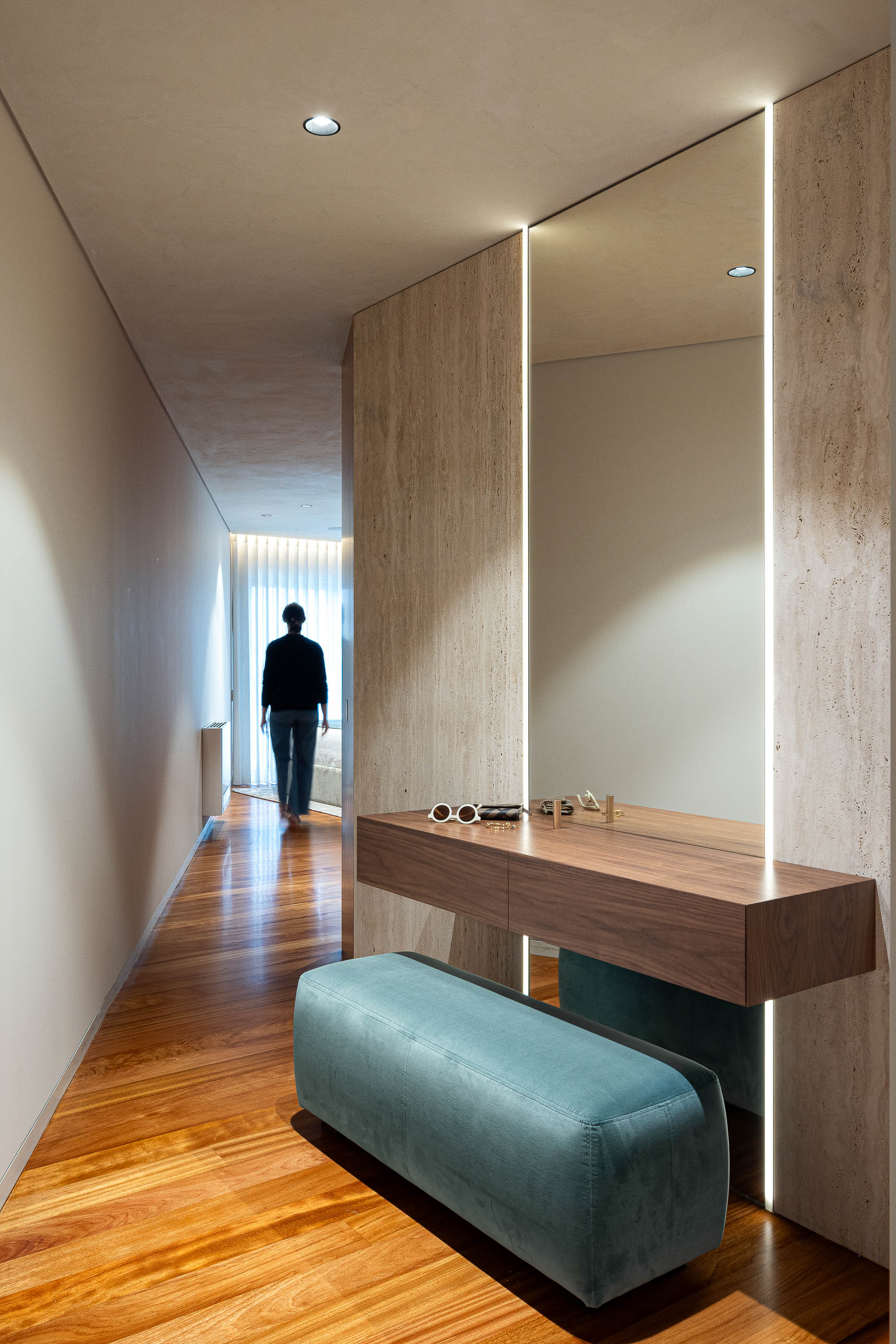 Corredor: Espelho com iluminação embutida, consola em madeira e banco azul turquesa. — Lugar Comum arquitetura edmundo* architecture + planning em vila do conde