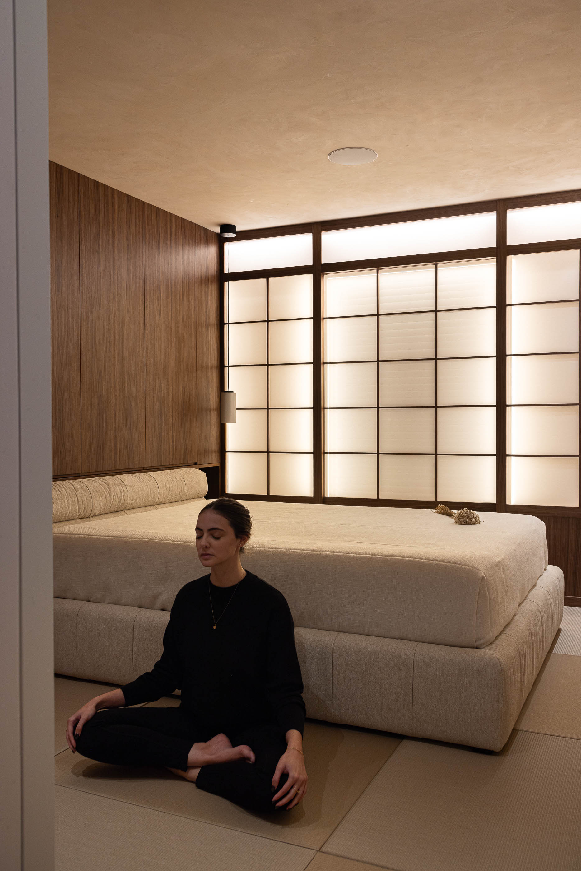 Quarto: Cama baixa com painel japonês retroiluminado e tatami no pavimento. — Lugar Comum arquitetura edmundo* architecture + planning em vila do conde